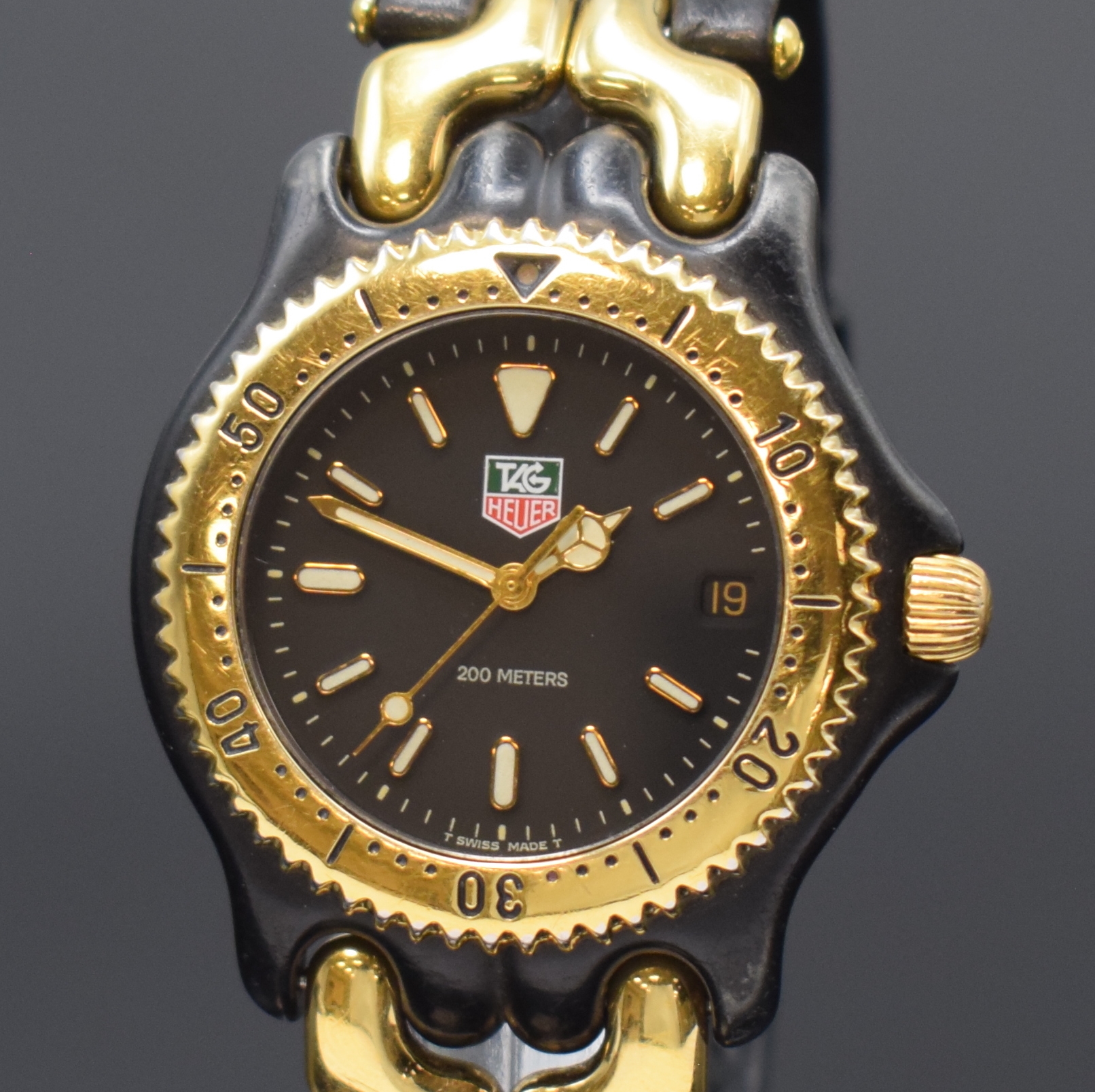 Detail a: TAG HEUER Armbanduhr Referenz S93.306, Schweiz um 1990, PVD-beschichtetes Edelstahlgeh. z. T. vergoldet, Boden und Krone verschr., Lün. m. 60er ...