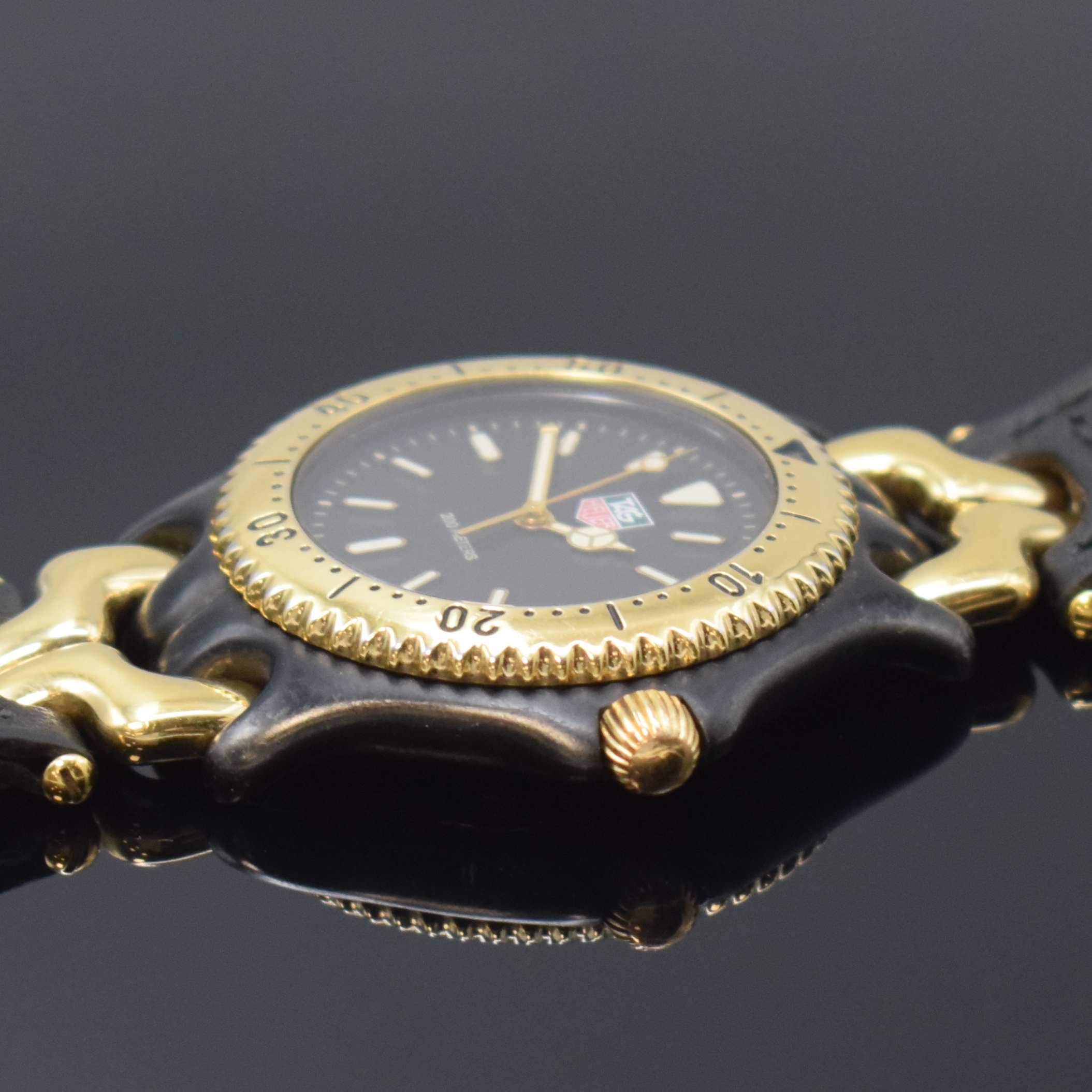 Detail b: TAG HEUER Armbanduhr Referenz S93.306, Schweiz um 1990, PVD-beschichtetes Edelstahlgeh. z. T. vergoldet, Boden und Krone verschr., Lün. m. 60er ...