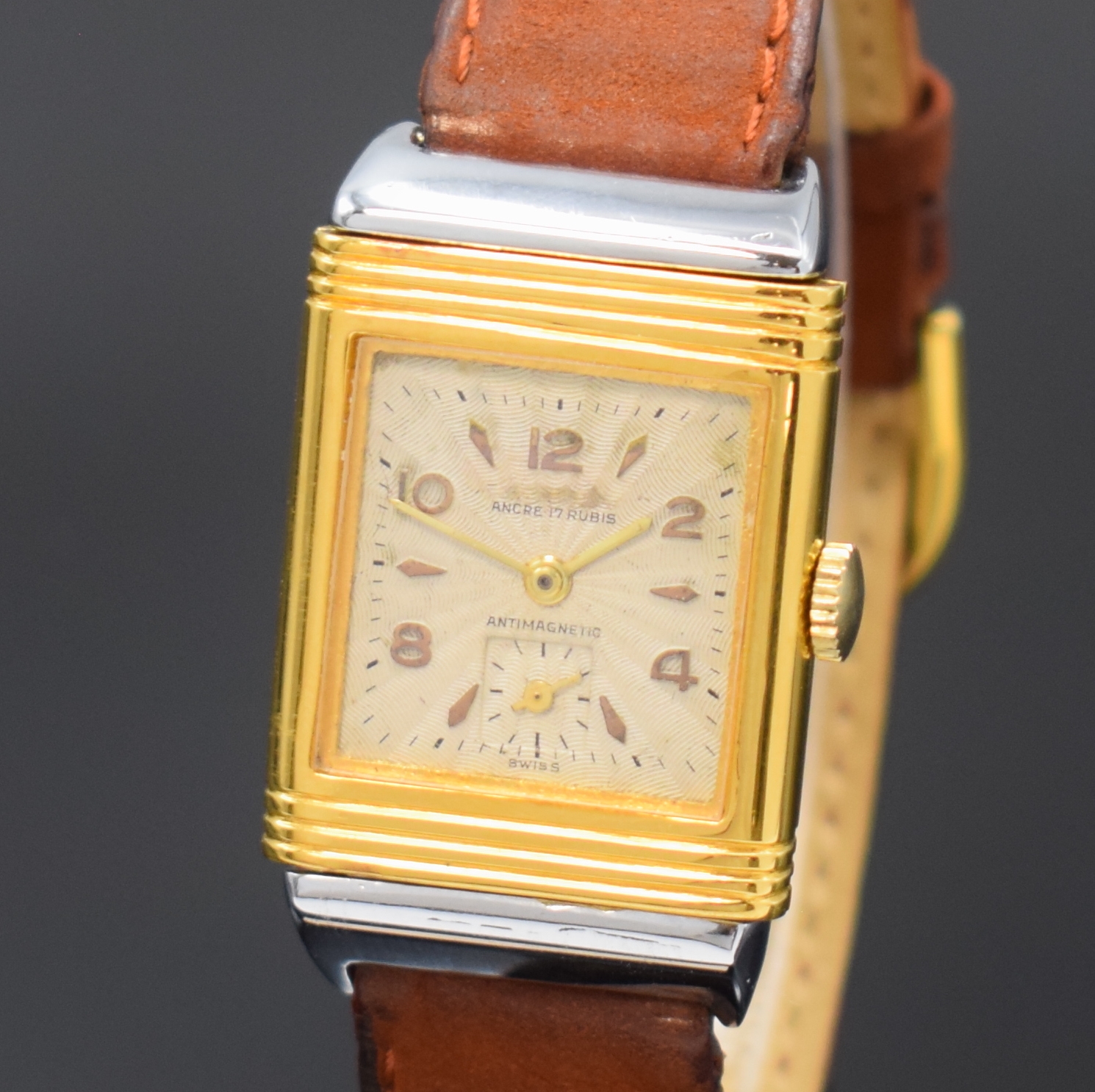 Detail a: Rechteckige Armbanduhr mit Wendegehäuse, Schweiz 2. Hälfte 20. Jahrhundert, Handaufzug, verchromt/vergoldet, silb. strahlenförmig strukturiertes ...