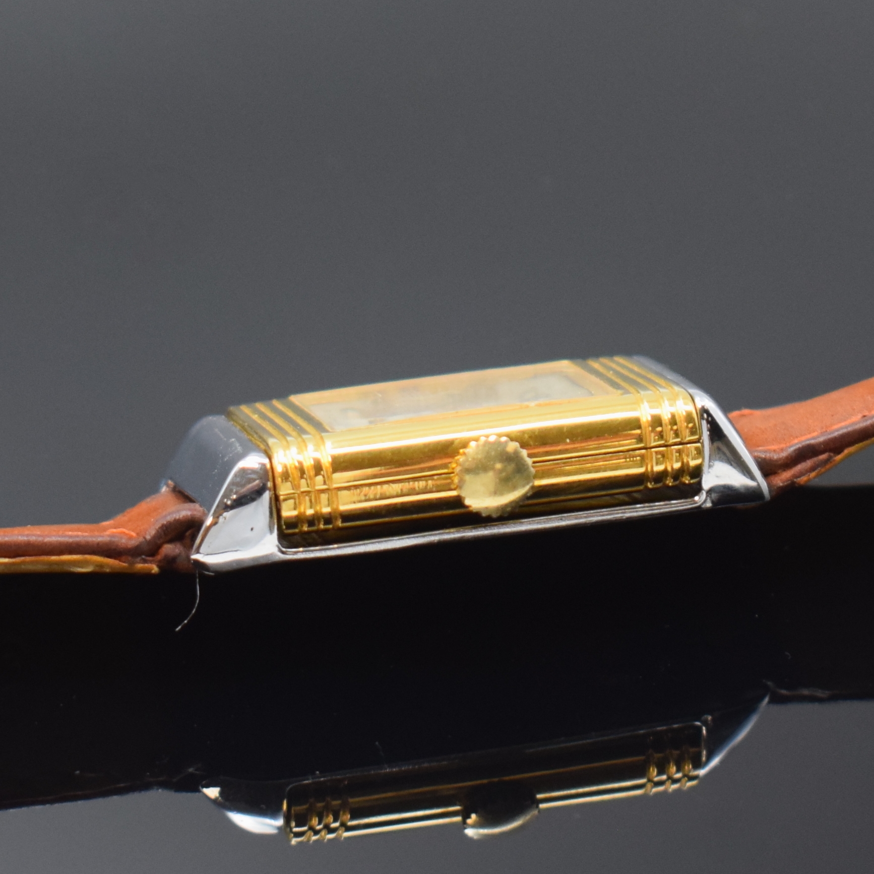 Detail e: Rechteckige Armbanduhr mit Wendegehäuse, Schweiz 2. Hälfte 20. Jahrhundert, Handaufzug, verchromt/vergoldet, silb. strahlenförmig strukturiertes ...