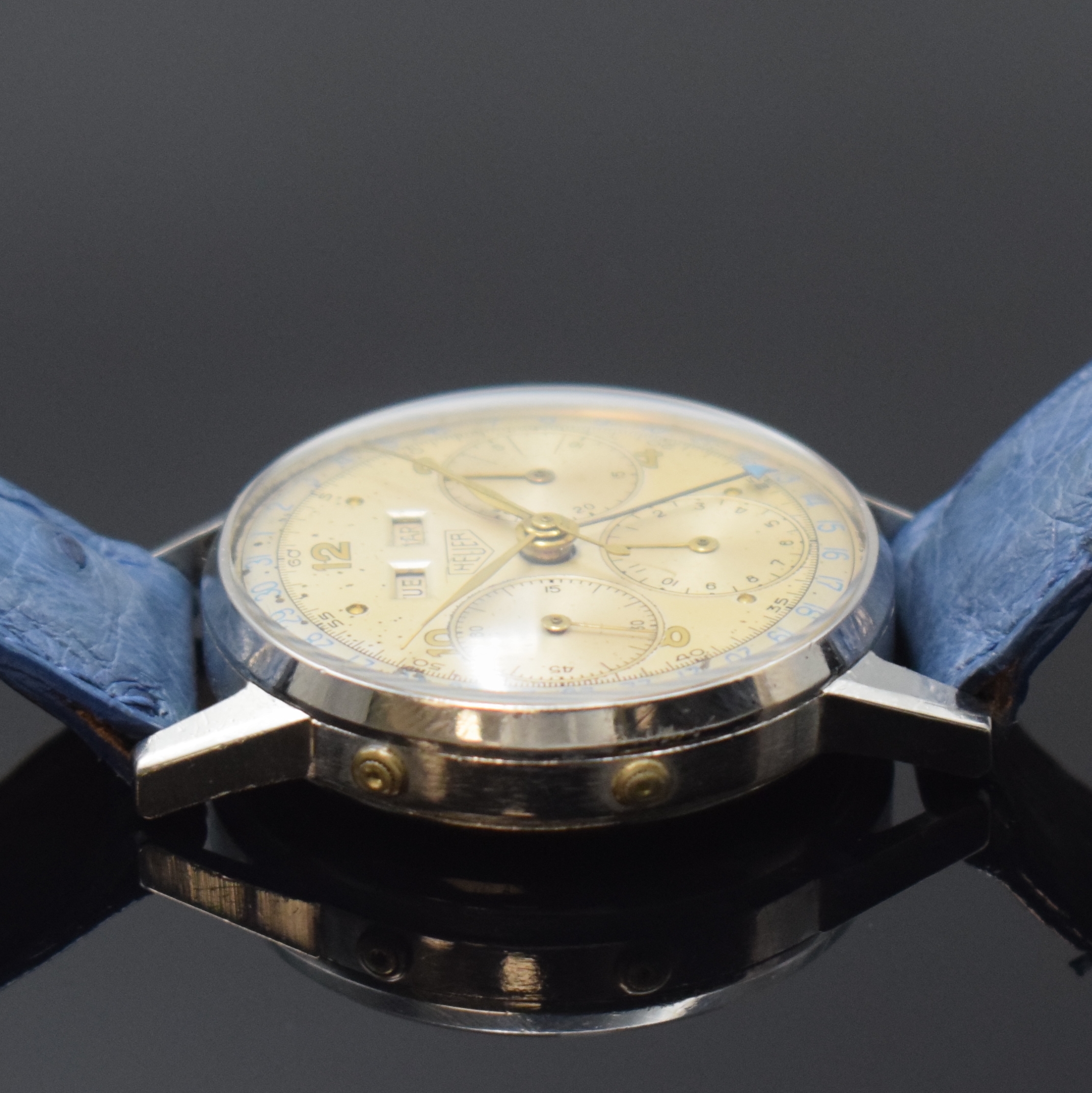 Detail d: HEUER Valjoux 72C Herrenarmbanduhr mit Schaltradchronograph und Vollkalender in Stahl, Schweiz um 1955, Handaufzug, 3-tlg. Geh., Boden und Glasrand ...
