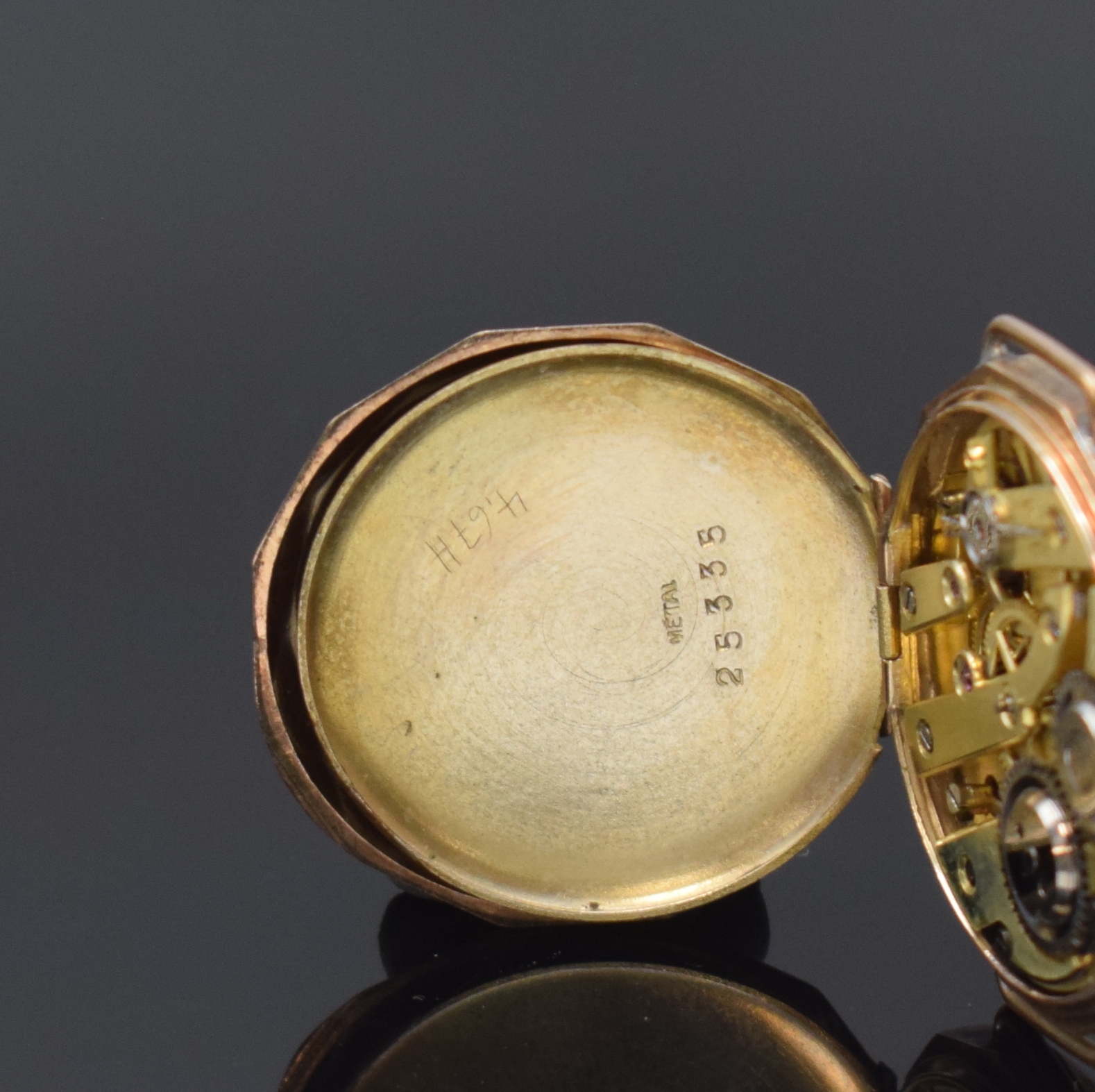 Detail d: Offene Taschenuhr umgebaut zur Armbanduhr in RoseG 333/000, Schweiz um 1890, Geh. dell., guill. Rückdeckel m. Monogrammspiegel, Metallcuvette, ...