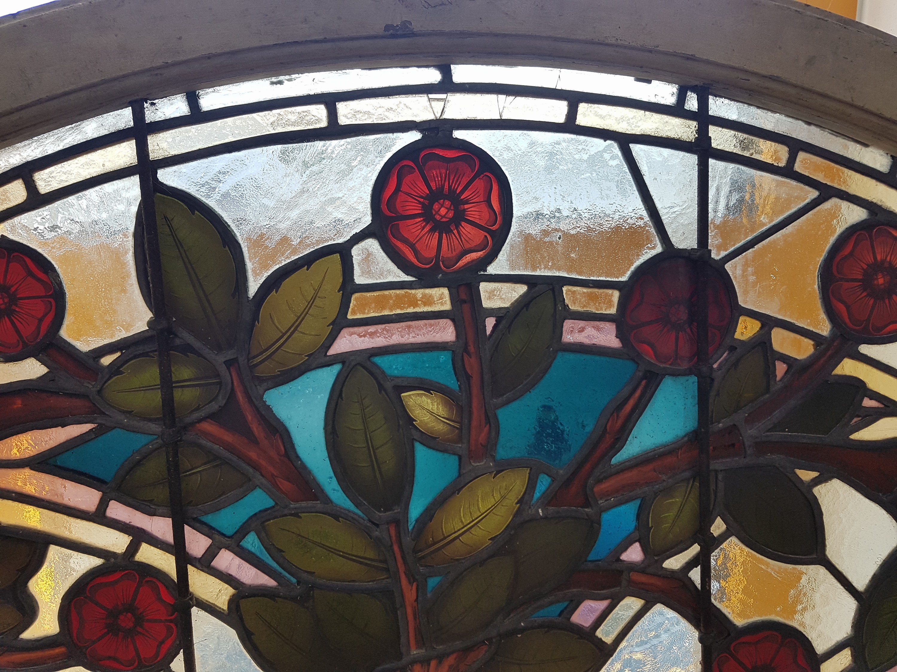 Detail b: Bleiglasfenster, wohl Belgien, um 1900, farbiges Glas mit Blei-Stegen, Holzrahmen, Blütenzweigdekor, bogenförmig als Kämpferfenster verwandt, ...