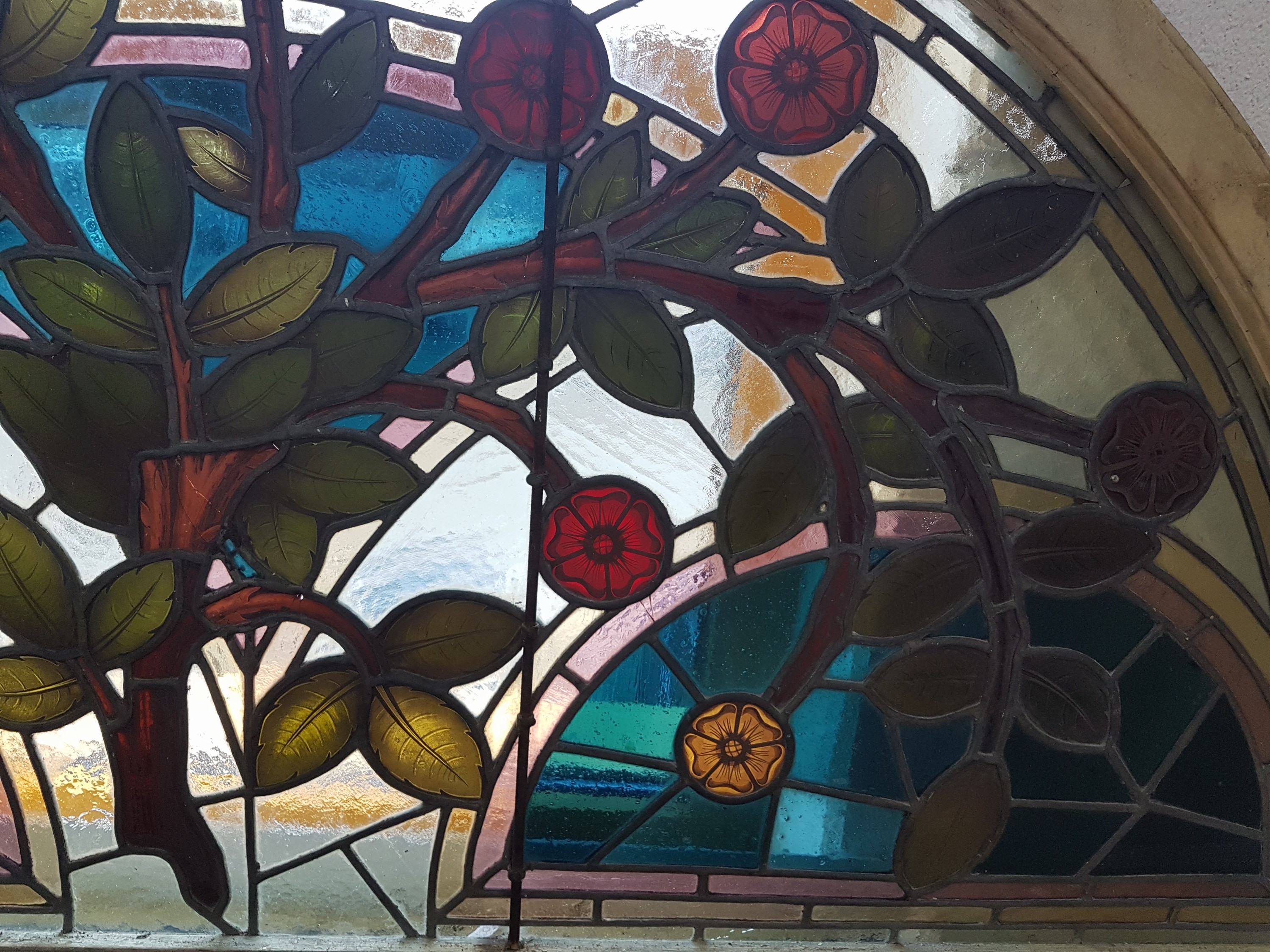 Detail d: Bleiglasfenster, wohl Belgien, um 1900, farbiges Glas mit Blei-Stegen, Holzrahmen, Blütenzweigdekor, bogenförmig als Kämpferfenster verwandt, ...