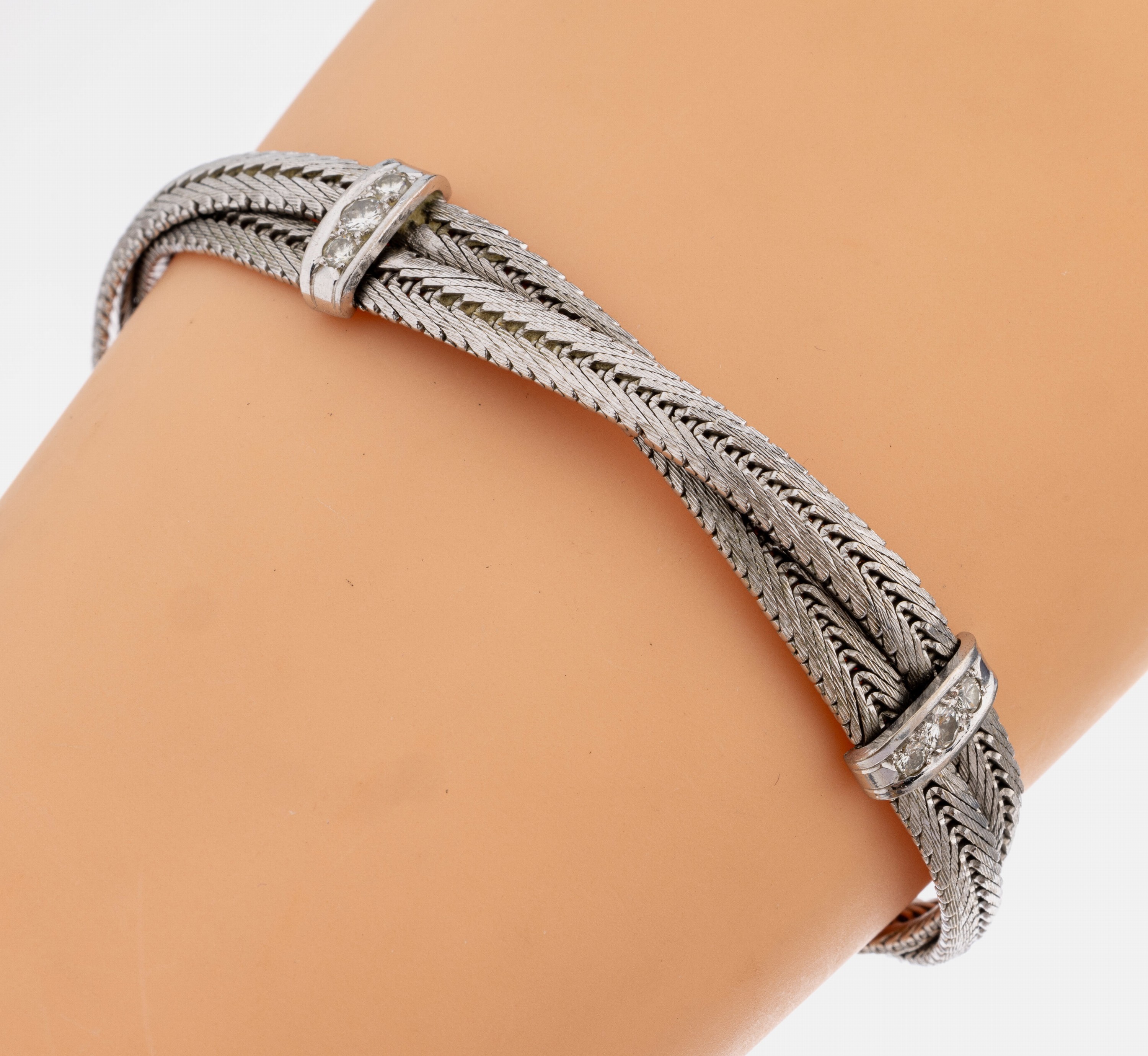 18 kt Gold Brillant-Armband, WG 750/000, Flechtoptik, bes. mit 12 Brillanten zus. ca. 0.65 ct Weiß/si-p 1, L. ca. 18.5 cm, ca. 30 g,Steckschloss ...