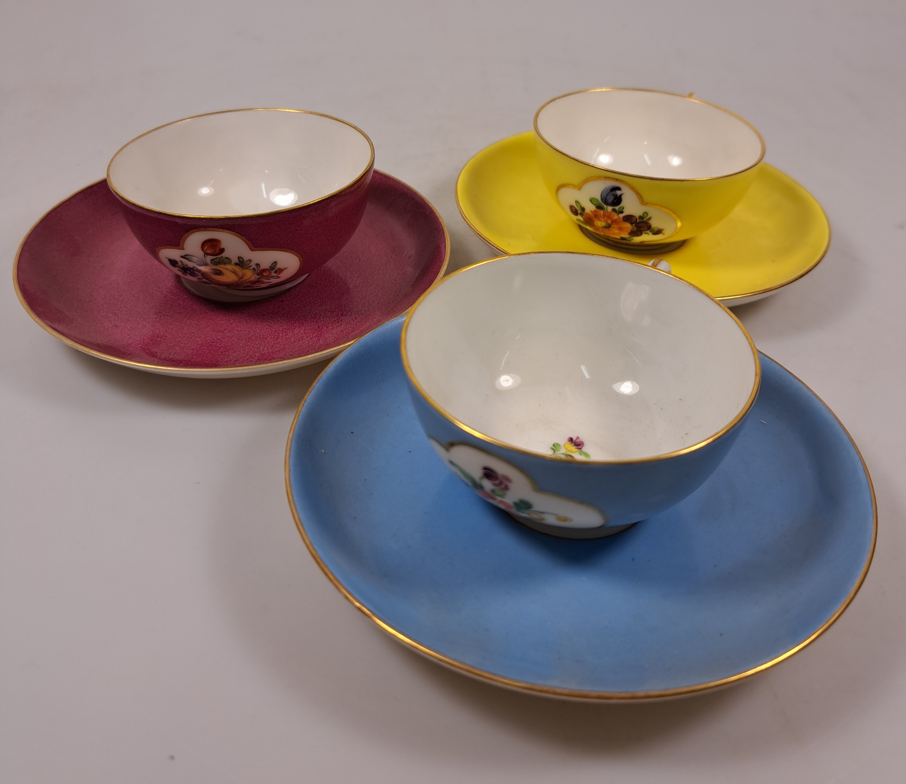 Detail b: 10 Mokkatassen, 2. Hälfte 20. Jh., u.a. Meissen B-Form; KPM 2. Wahl; Coalport; drei Nymphenburger Tassen mit Blumenmalerei in Gelb, Blau und Purpur; ...