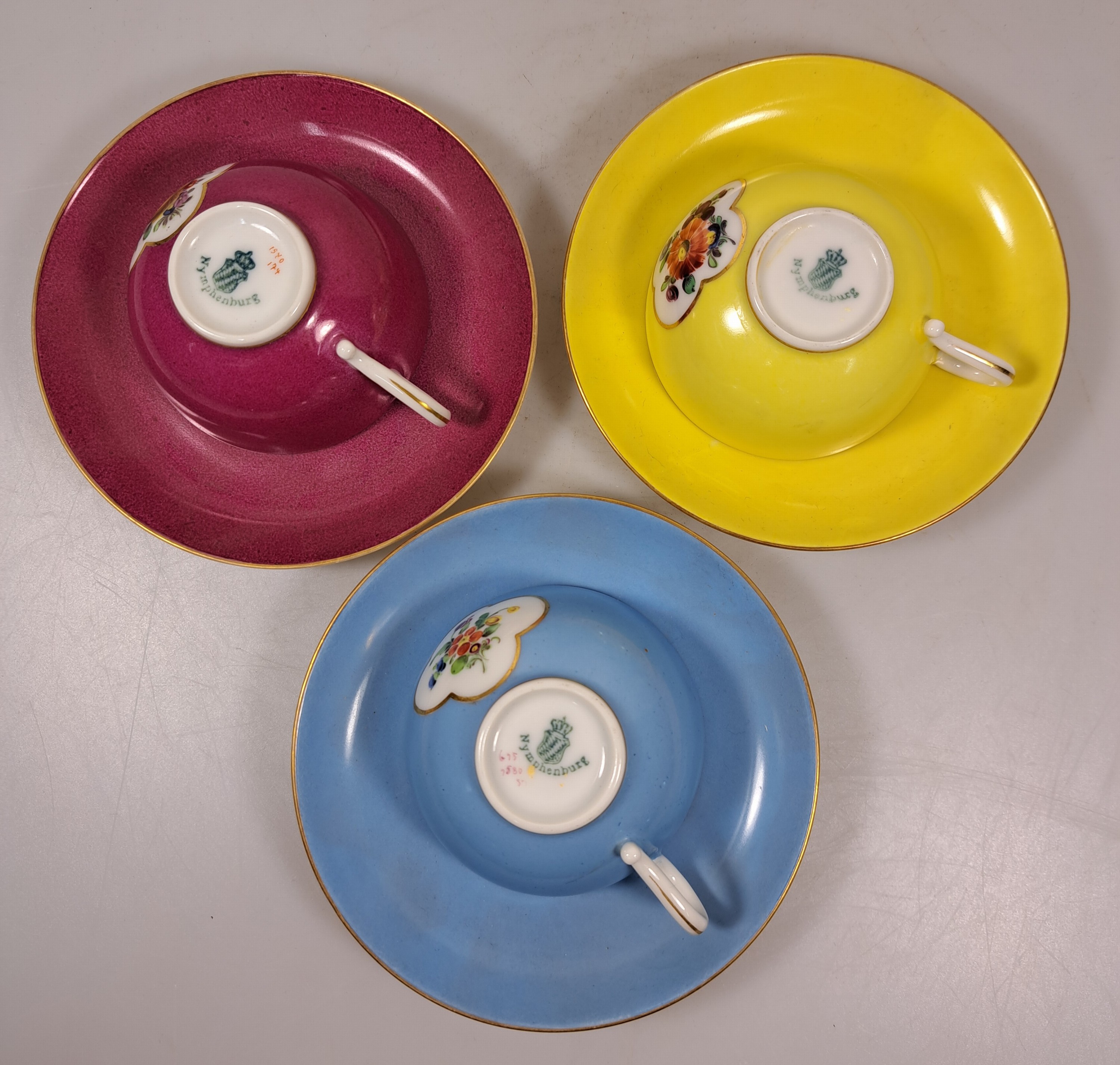Detail c: 10 Mokkatassen, 2. Hälfte 20. Jh., u.a. Meissen B-Form; KPM 2. Wahl; Coalport; drei Nymphenburger Tassen mit Blumenmalerei in Gelb, Blau und Purpur; ...
