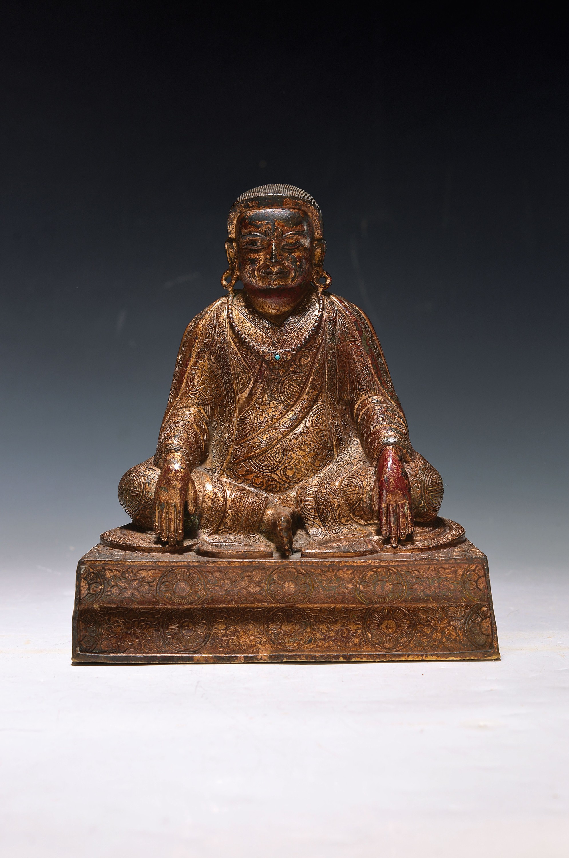 Bronzefigur eines Lamas, Tibet, 19. Jh., Bronze, reich verziertes Gewand, orig. Vergoldung altersbedingt berieben, ca. 18.5 x 16.5 x 9.7 cm