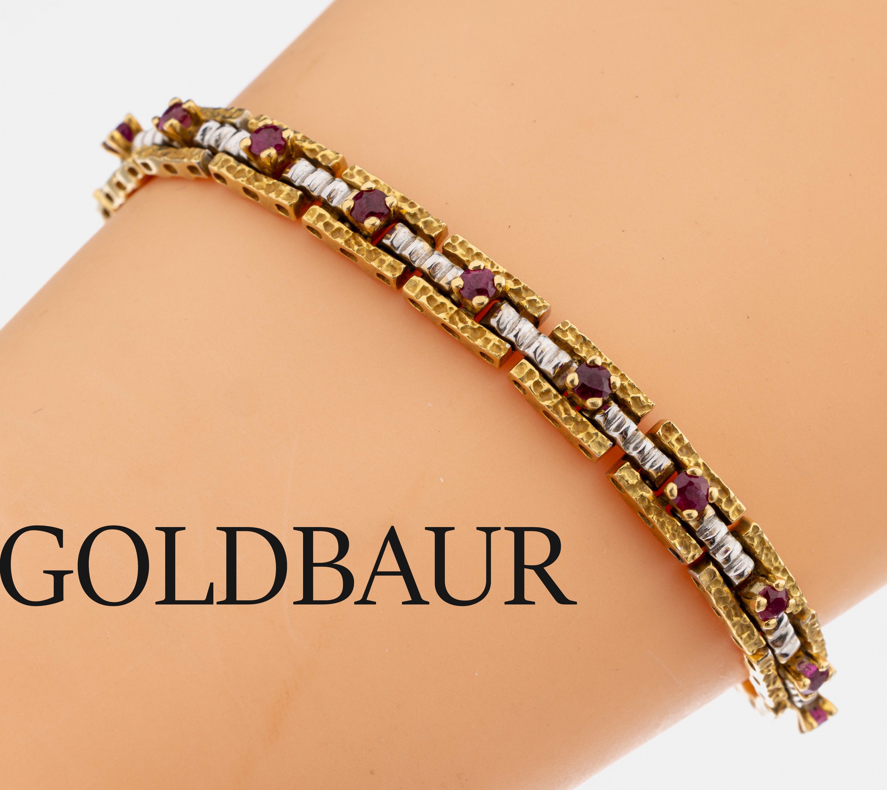 18 kt Gold GOLDBAUR Rubin-Armband, GG/WG 750/000, 19 rundfacett. Rubine, typ. aufwändige Verarbeitung, L. ca. 18 cm, Kastenschloss mit ...