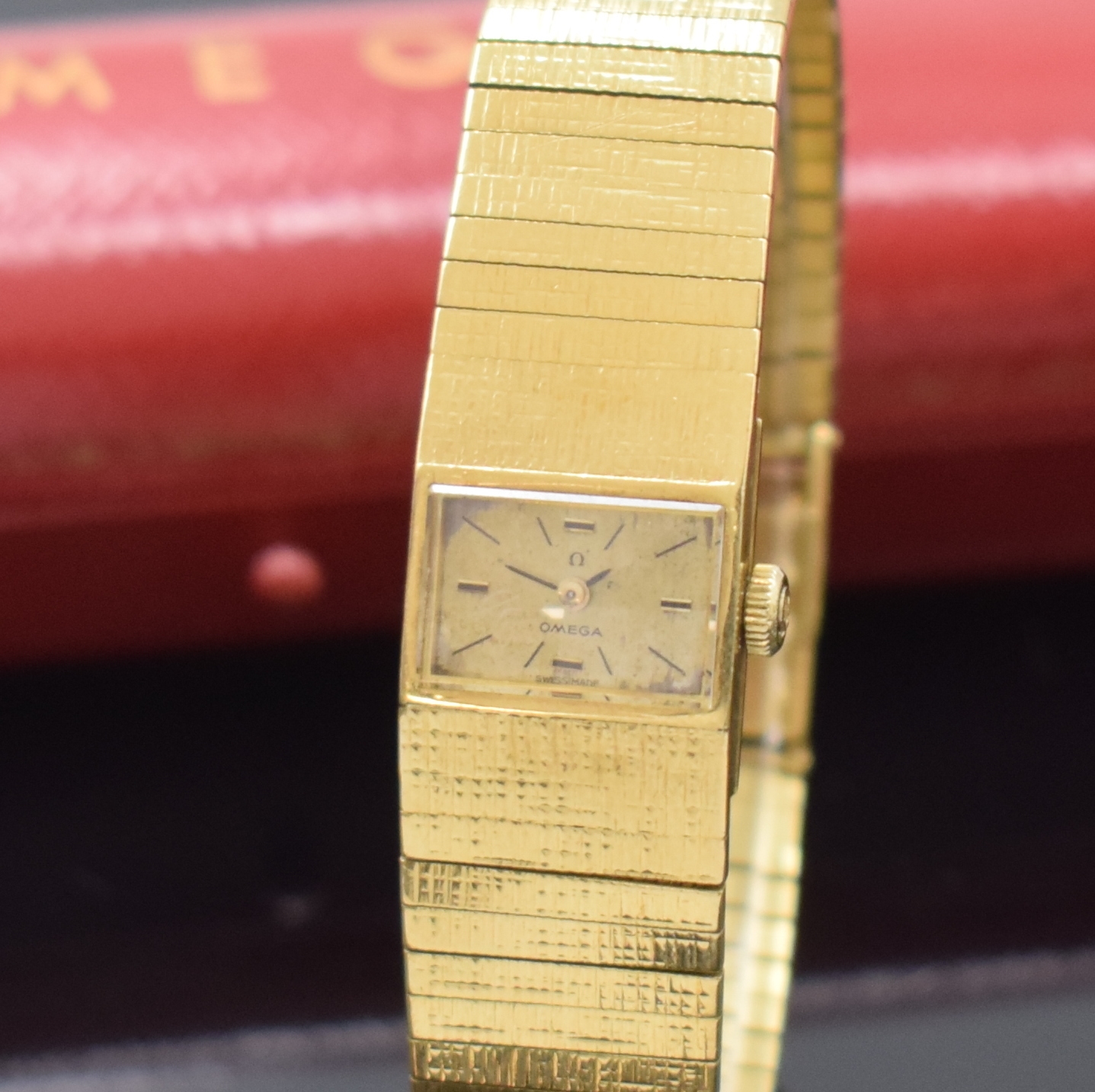 Detail a: OMEGA Damenarmbanduhr in GG 750/000, Schweiz um 1965, Handaufzug, orig. Goldband, Boden aufgedr., silb. Zifferbl. fl./pat., 4 Std.- Ind., schwarze ...