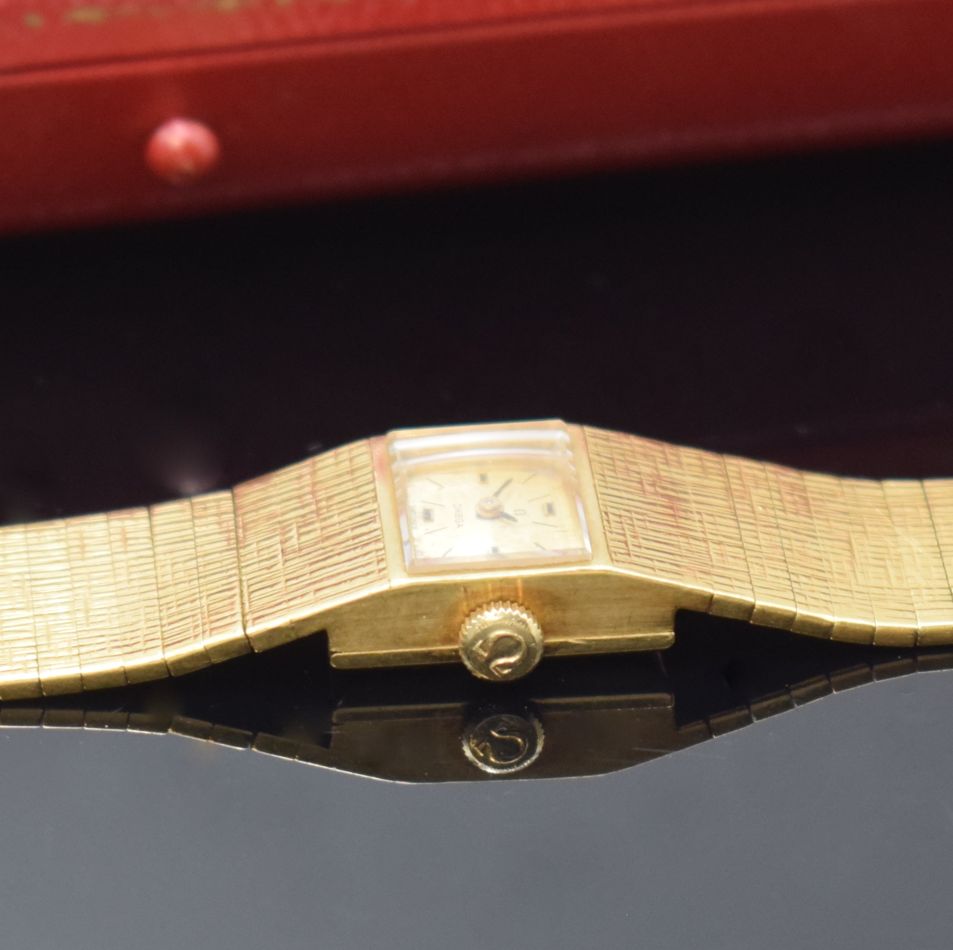Detail d: OMEGA Damenarmbanduhr in GG 750/000, Schweiz um 1965, Handaufzug, orig. Goldband, Boden aufgedr., silb. Zifferbl. fl./pat., 4 Std.- Ind., schwarze ...