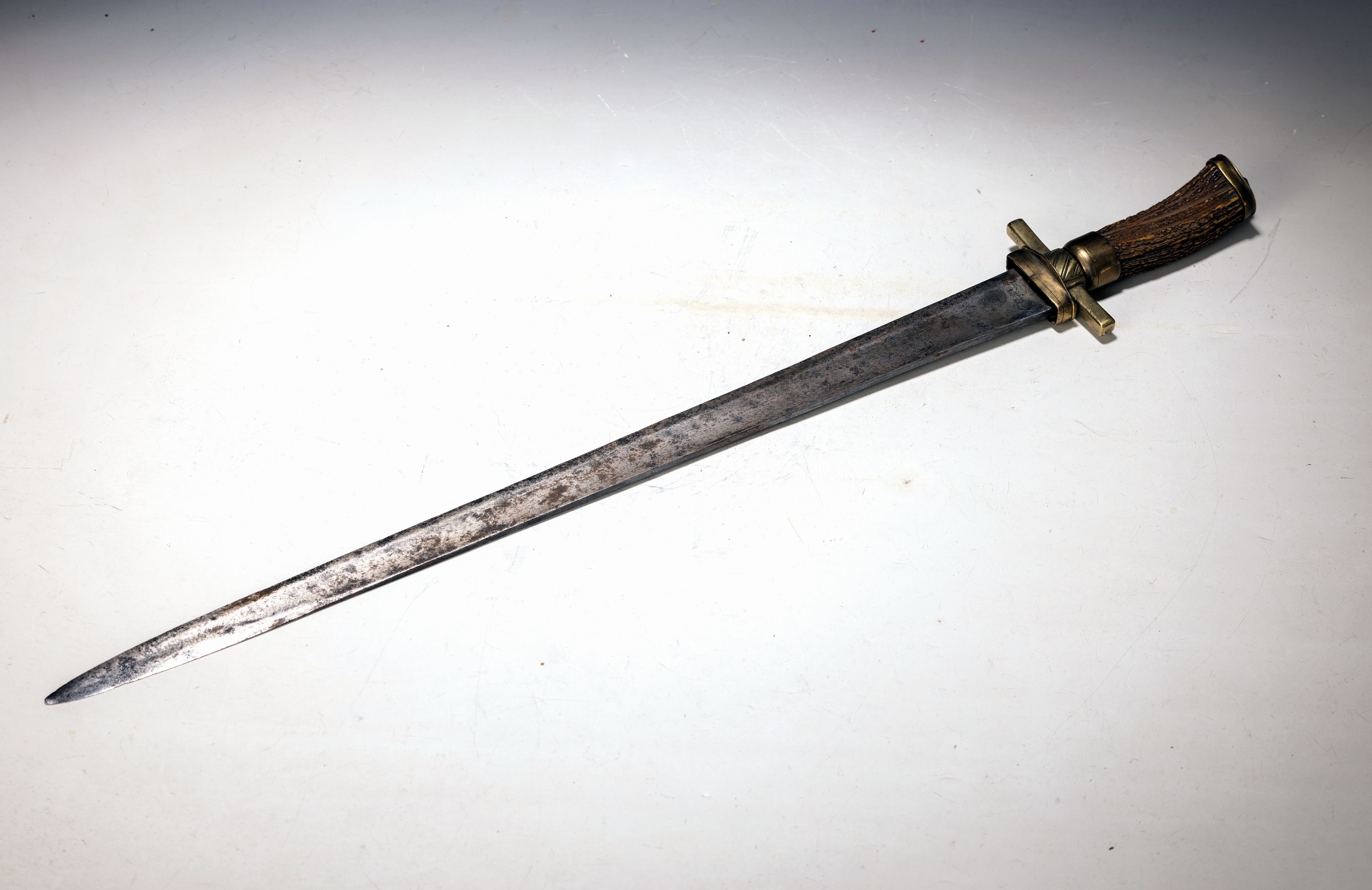 Großer Hirschfänger, deutsch, 18./19. Jh., Horngriff, Messingmontur, korrodierte Klinge mit Resten von Gravur, Altersspuren, L. ca. 72 cm
