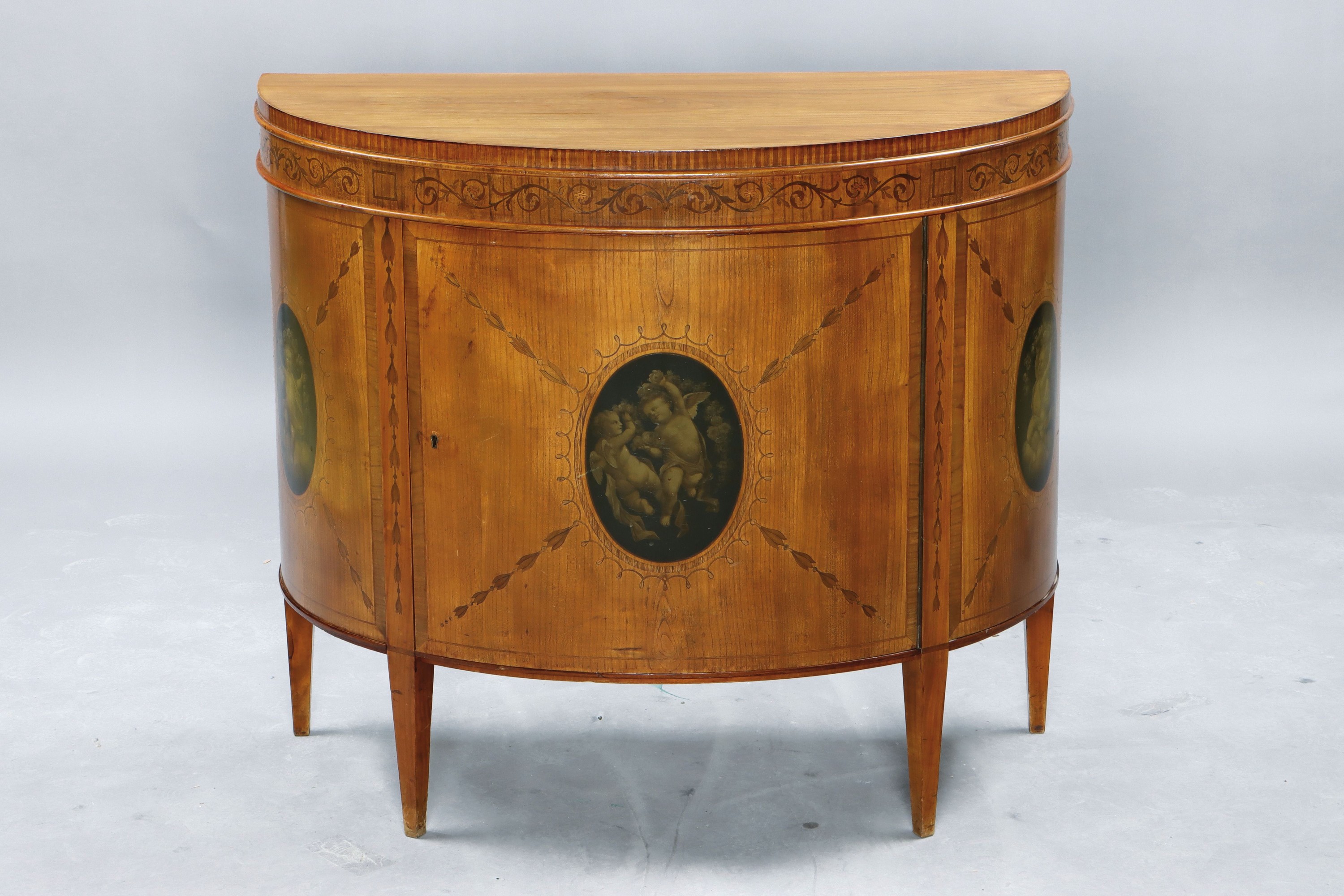 Halbschrank/Demi-Lune, im klassizistischem Stil, um 1900, Kirschbaumfurnier, mit verschiedenen Hölzern furniert, Tür und Seiten medaillonförmig ...