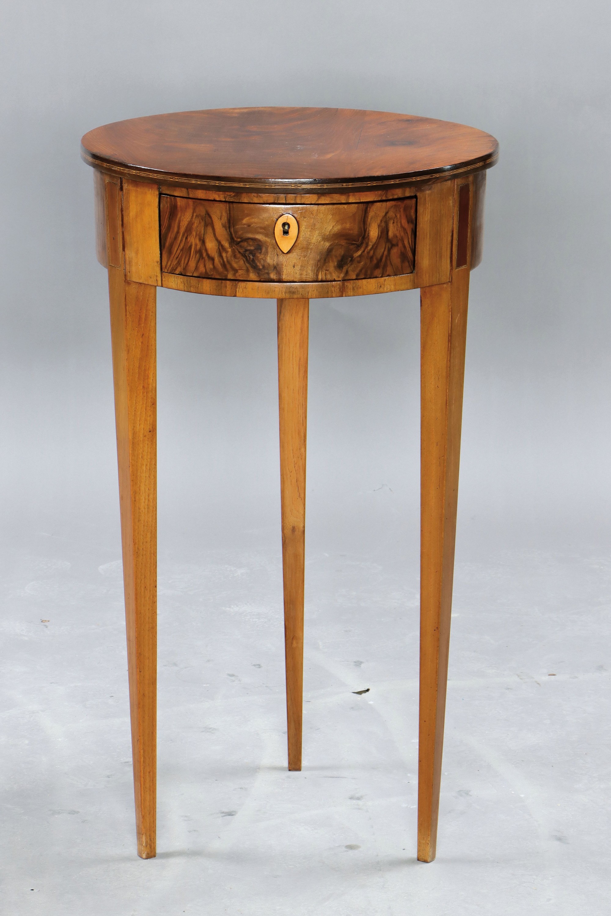 Beistelltisch, um 1820, Platte Mahagonifurnier, z.T. Nussbaumfurnier, eine Schublade, ein Schlüssel, H. ca. 74 cm, D. ca. 42 cm, EZ 2
