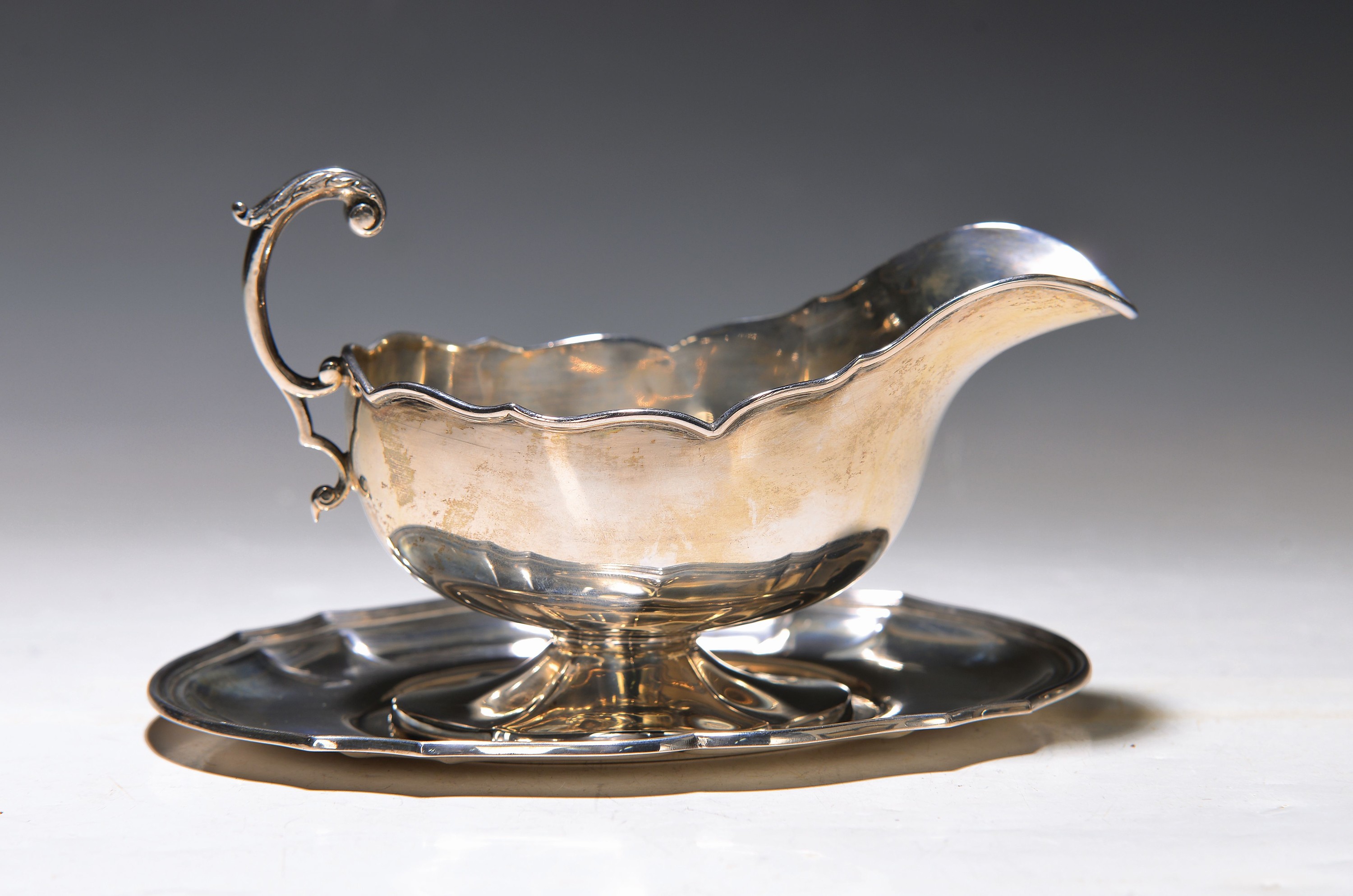 Sauciere mit Unterteller, 800er Silber, Anfang 20. Jh., Presentoir und Fuß vierpassförmig, l. verbeult, ca. 240 g