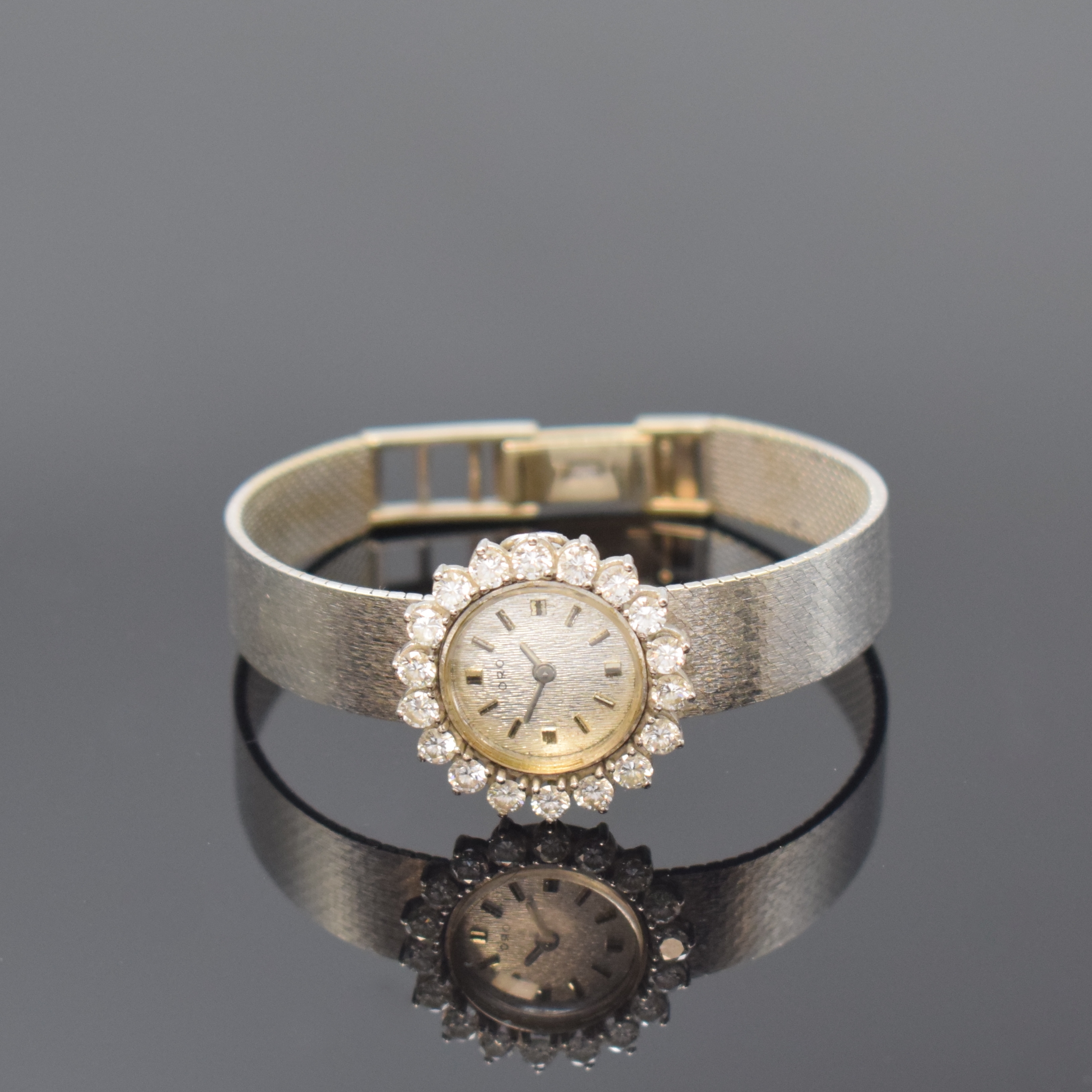 ORO Damenarmbanduhr in WG 750/000 mit Diamanten, Schweiz um 1965, Handaufzug, Goldband, Boden aufgedr., Lünette aufw. m. 18 Diamanten bes., silb. ...