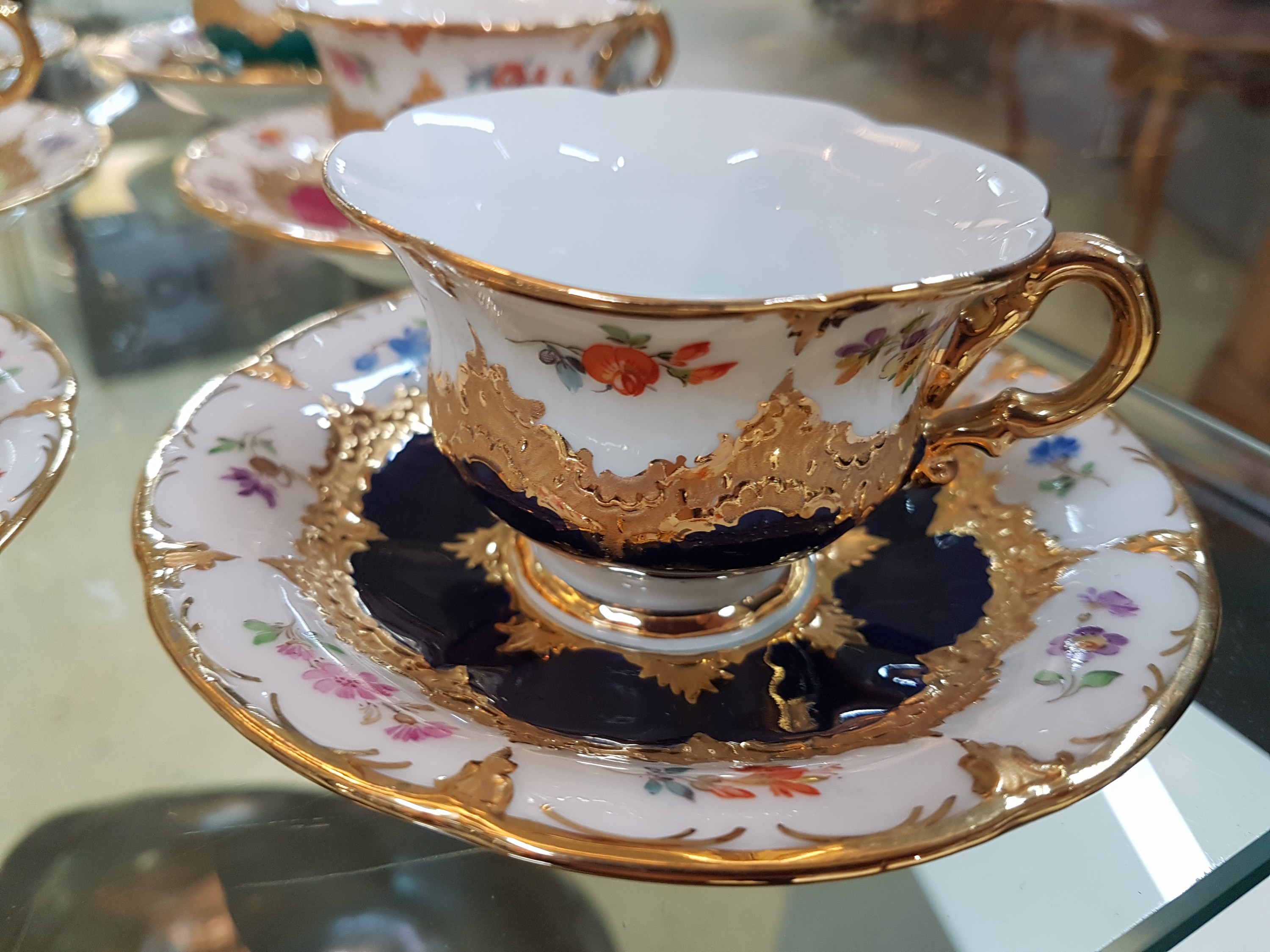 Detail c: 6 Mokkatassen, Meissen, B-Form, 20. Jh., versch. farbige Tassen mit gestreuten Blümchen, Matt- und Glanzvergoldung, mit Untertassen