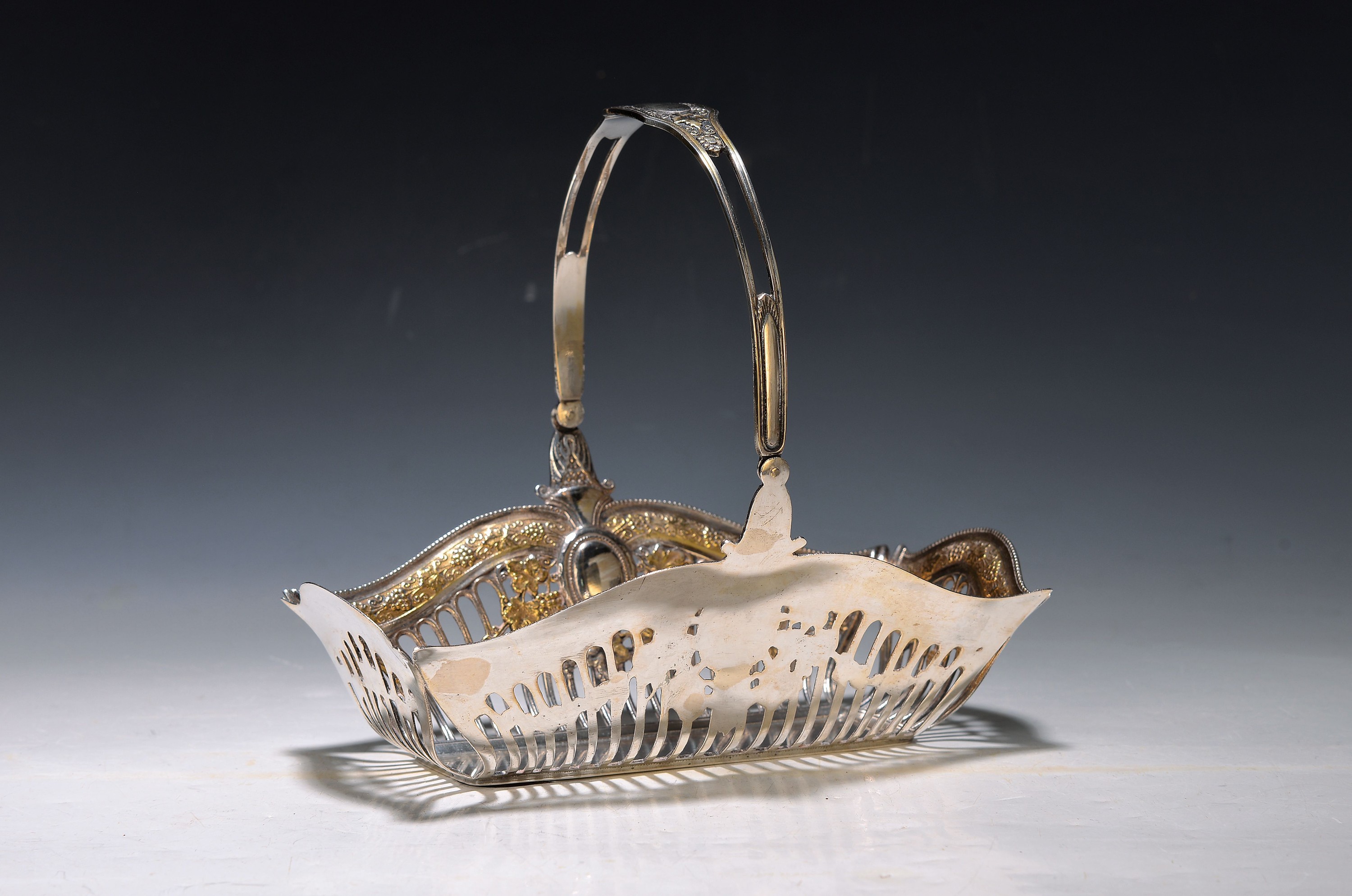 Henkelkörbchen, klassizistisch, 20. Jh., 900er Silber, Wandung in Durchbrucharbeit, Weinlaubdekor, partiell vergoldet, teilweise berieben, ca. 19 x ...