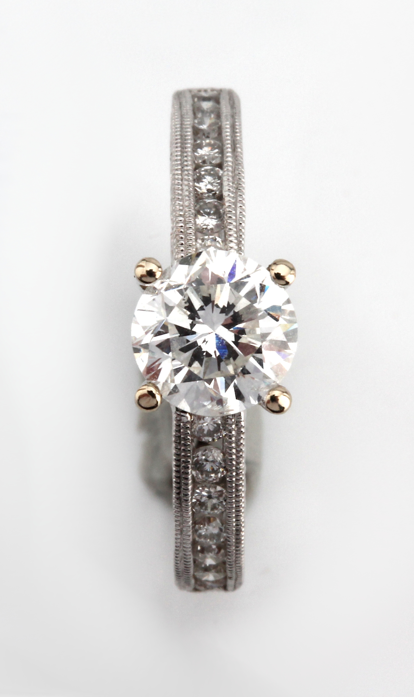 Detail c: 18 kt Gold Brillant-Ring, WG 750/000, mittig erhaben gefasster Brillant ca. 1.01 ct (grav.) Weiß/si, Ringschultern mit 14 Brillanten zus. ca. 0.23 ...