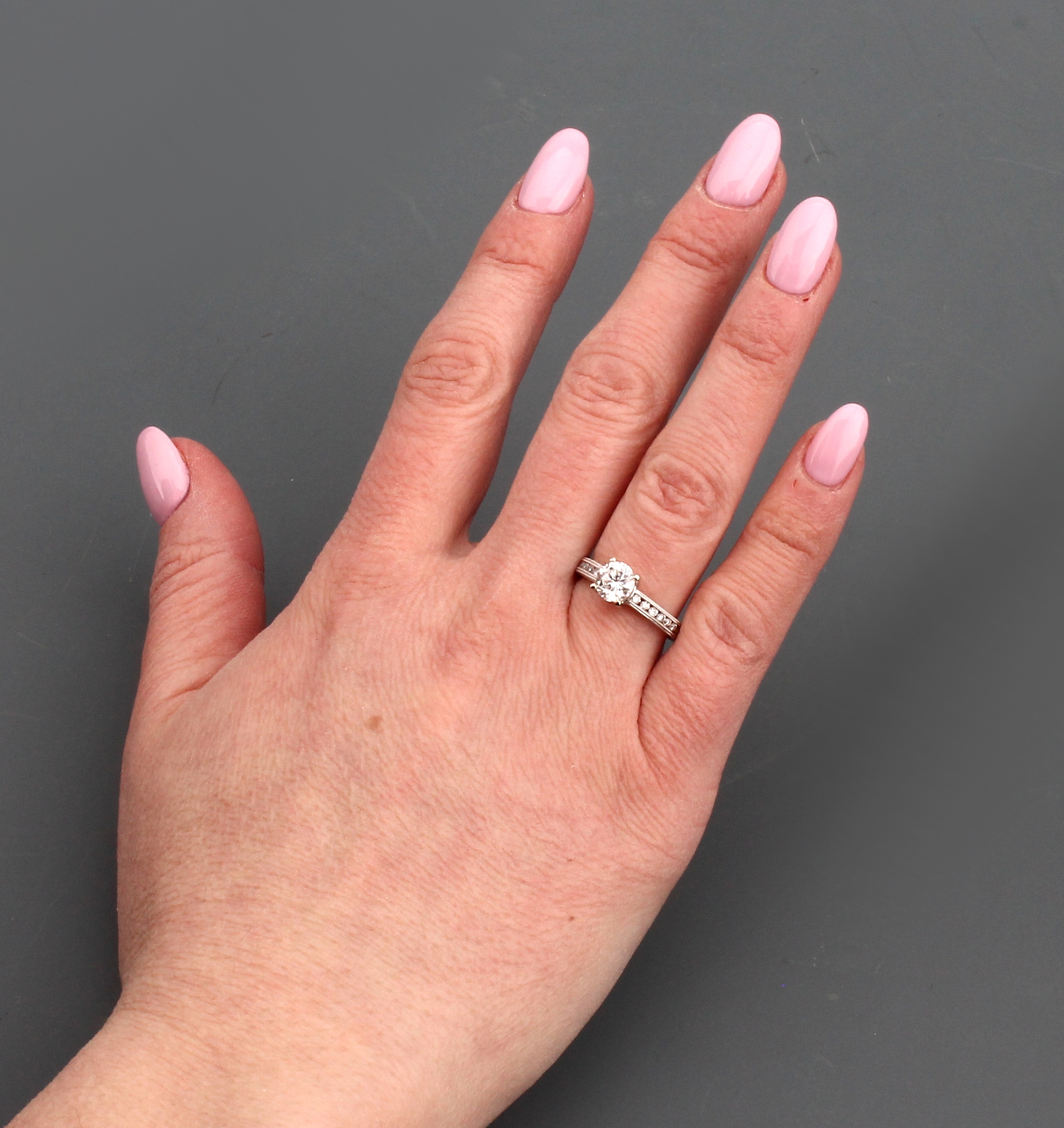 Detail d: 18 kt Gold Brillant-Ring, WG 750/000, mittig erhaben gefasster Brillant ca. 1.01 ct (grav.) Weiß/si, Ringschultern mit 14 Brillanten zus. ca. 0.23 ...