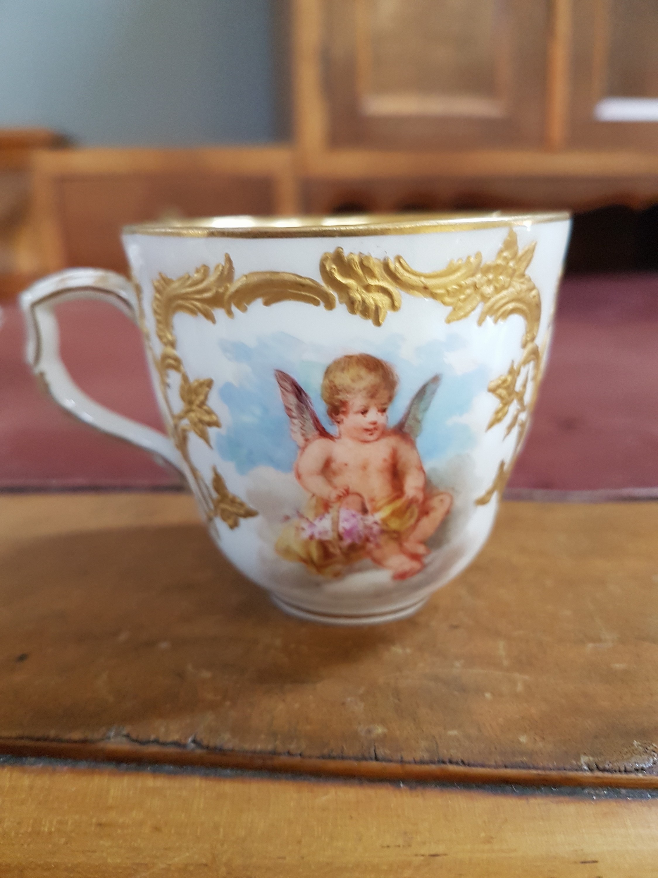 Detail j: Mokkatasse mit Untertasse, KPM Berlin, um 1900, Form Neuzierat, sog. fliegende Kinder, fein gemalte Putten mit verschiedenen Attributen in ...