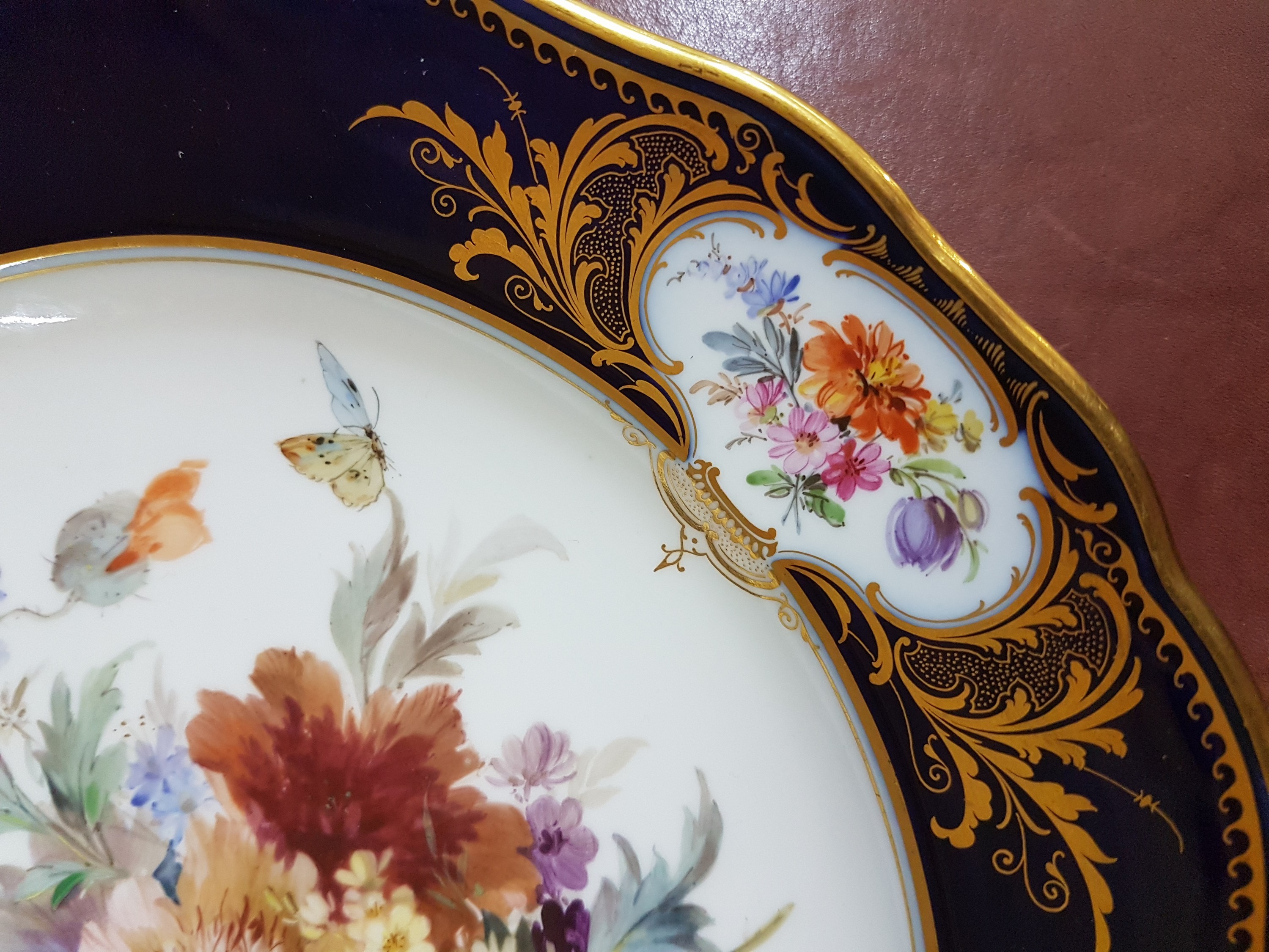 Detail d: Prunkteller/Speiseteller, Meissen, um 1900, Amsterdamer Art, Form Neuer Ausschnitt, kobaltblaue Fahne, im Spiegel und in drei Randkartuschen ...
