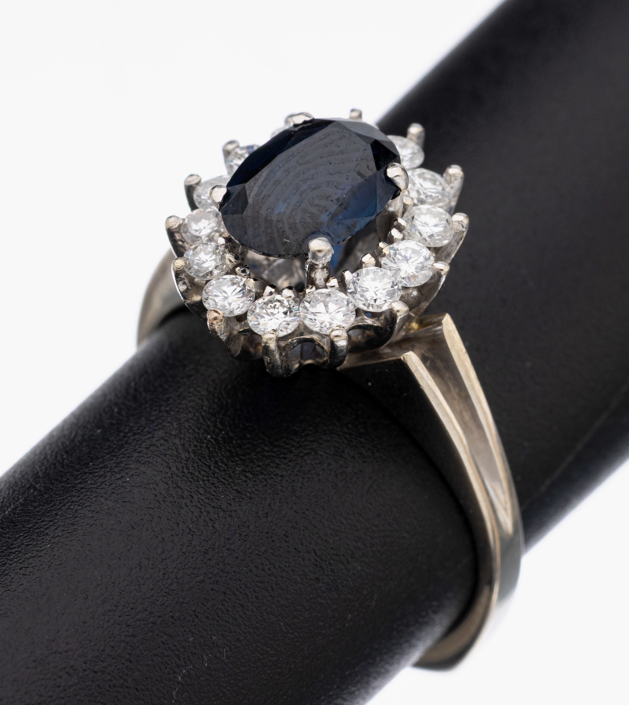 18 kt Gold Saphir-Brillant-Ring, WG 750/000, mittig ovalfacett. Saphir ca. 1.25 ct, umgeben von 14 Brillanten zus. ca. 0.43 ctWeiß/si, RW 54, ca. ...