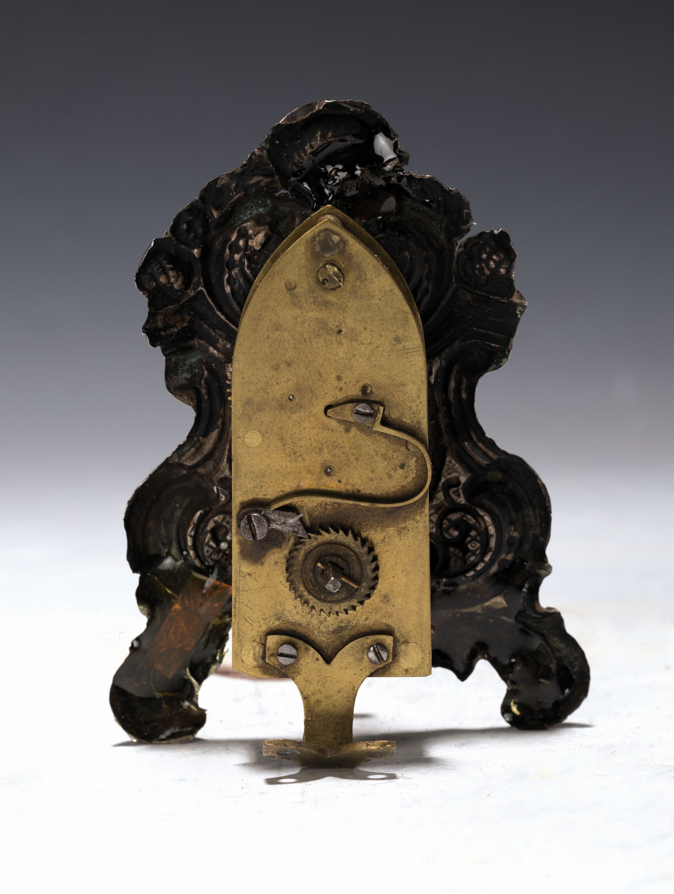 Detail a: Miniatur Vorderzapppler, süddt. um 1850, geprägte Messingfront versilbert, hinterer Standfuß, ehemals in kleinem Glasdom mit Holzsockel, ...