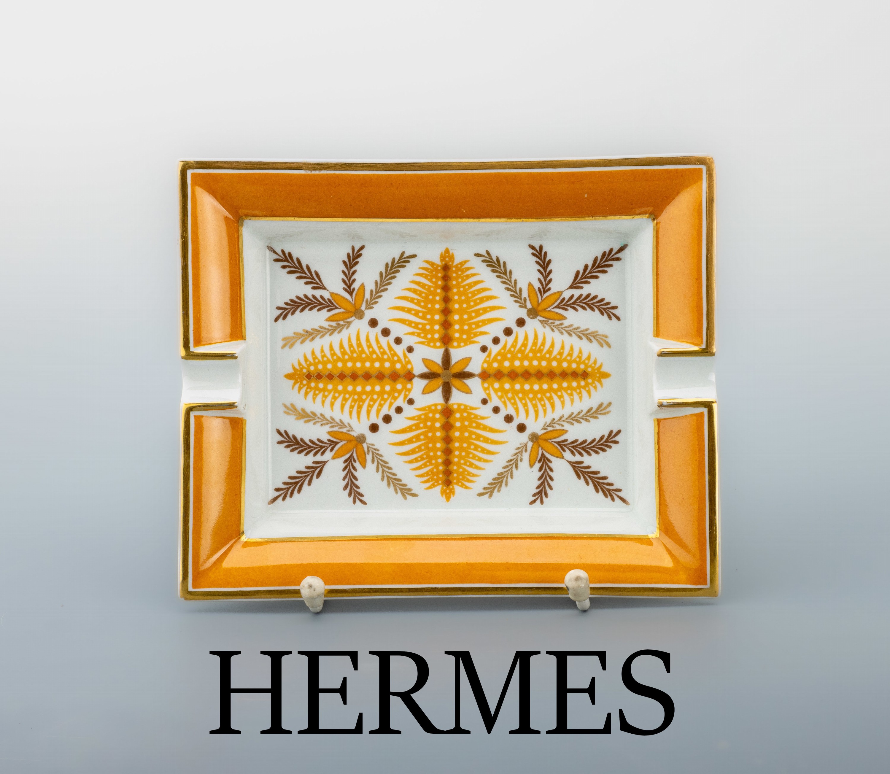 HERMES Aschenbecher, Porzellan, weißer Fond mit orangegelben, braunen und goldfarbenen Zweigen, Fahne orange Gelb, Rand goldgehöht, Boden mit ...