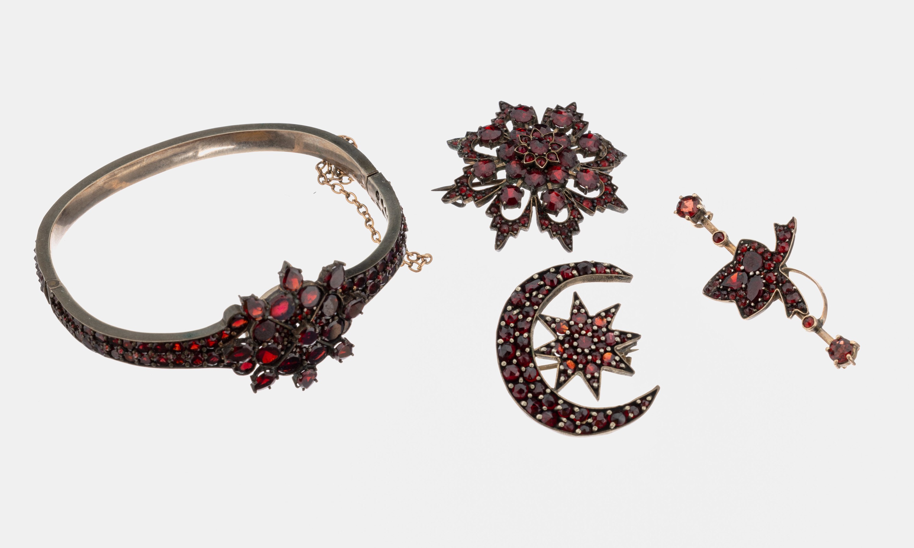 Granat-Schmuckset, um 1900, Metall verg., best. aus: 1 Armreif mit Spiegelgranaten und rundfacett. Granate, ca. 5 x 5.5 cm, Klappscharnier, ...