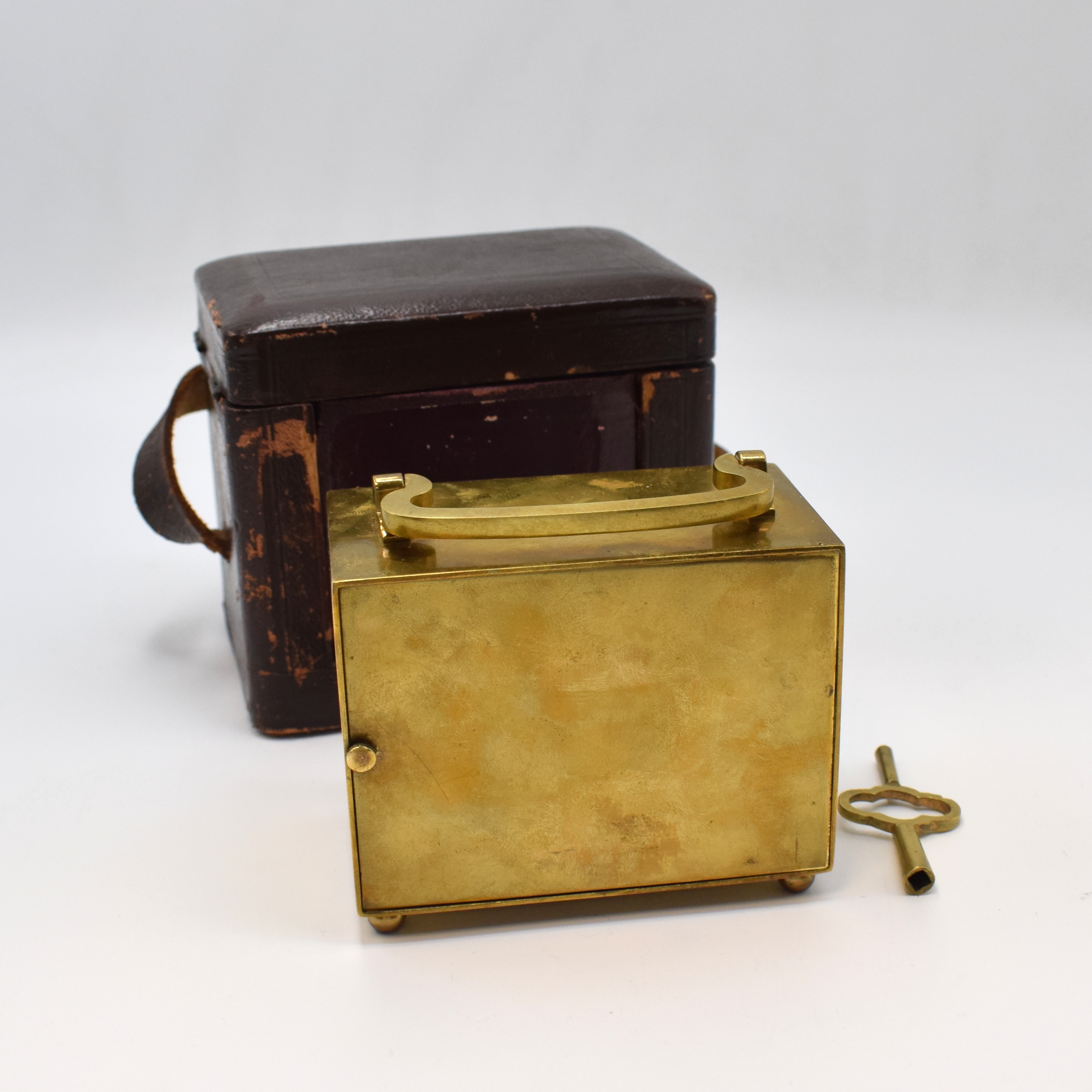 Detail b: Reiseuhr mit Wecker, Frankreich um 1920, Messinggeh. m. Tragegriff, vergl. orig. Transportbox u. Schlüssel, Emailzifferbl. besch., röm. Zahlen, ...