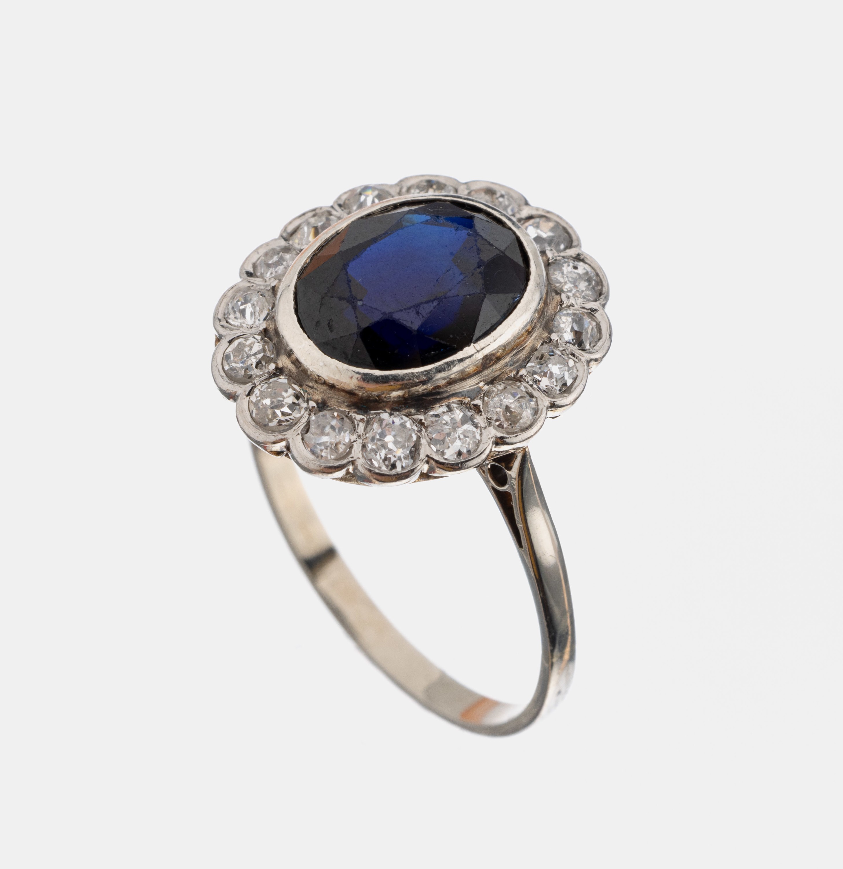14 kt Gold Saphir-Diamant-Ring, um 1920-30, WG 585/000 gepr., mittig ovalfacett. Saphir ca. 1.50 ct, umgeben von 16 Altschliffdiamanten zus. ca. 0.80 ...