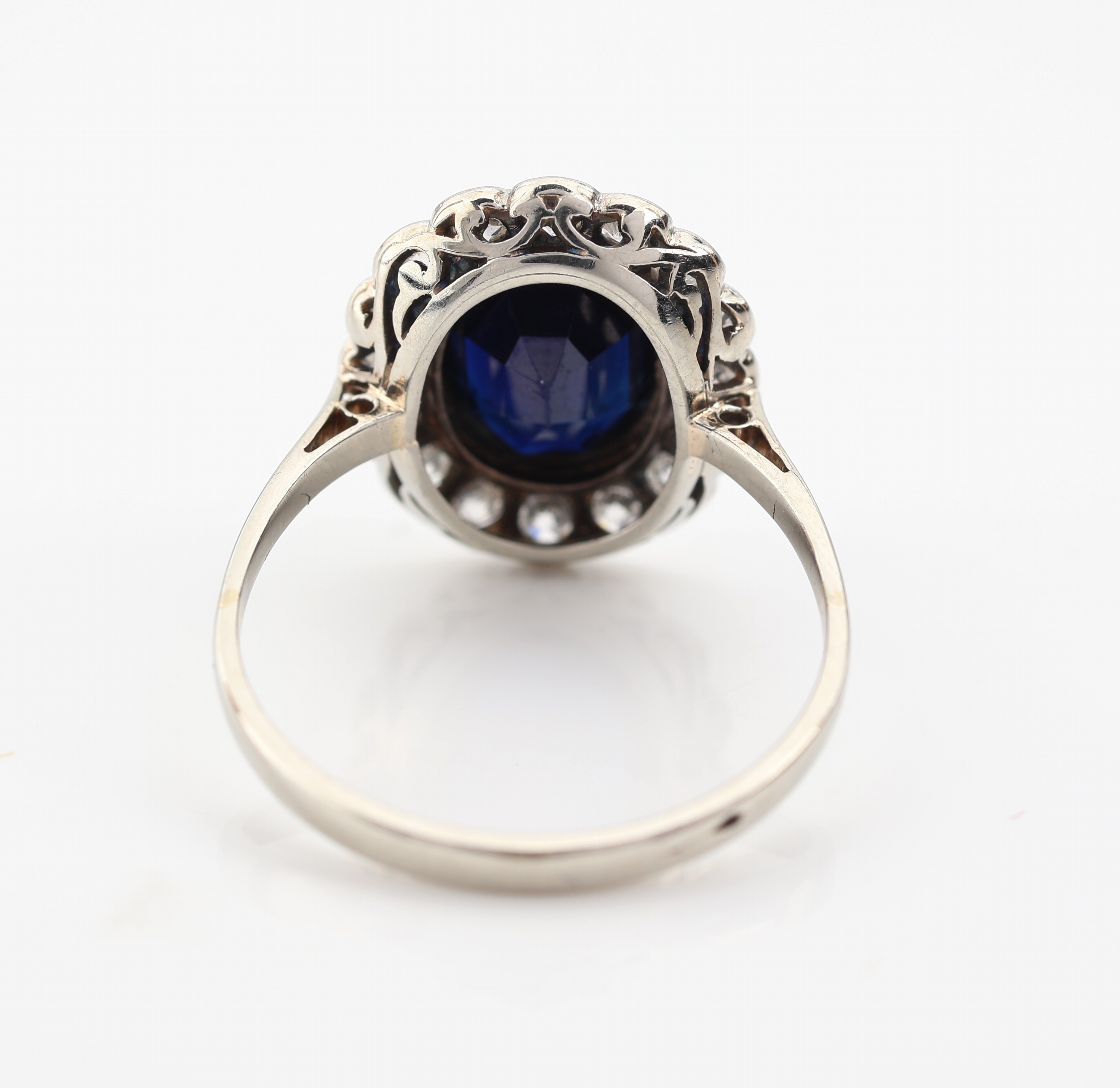 Detail c: 14 kt Gold Saphir-Diamant-Ring, um 1920-30, WG 585/000 gepr., mittig ovalfacett. Saphir ca. 1.50 ct, umgeben von 16 Altschliffdiamanten zus. ca. 0.80 ...