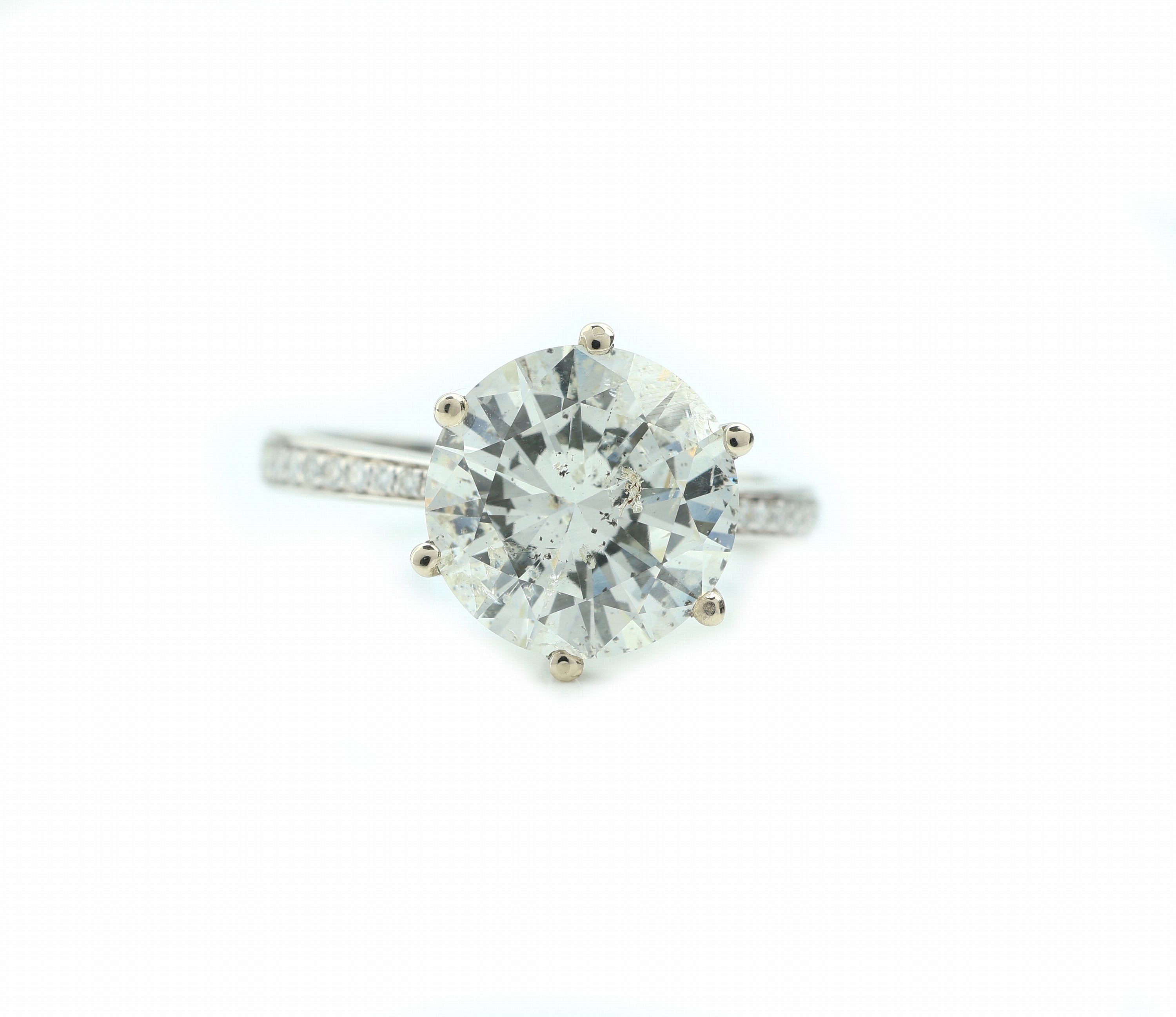 Detail a: 18 kt Gold Brillant-Ring, WG 750/000, Brillant ca. 4.62 ct l.get.Weiß-get.Weiß/p (beh.), seitl. flankiert von Brillanten zus. ca. 0.13 ct ...