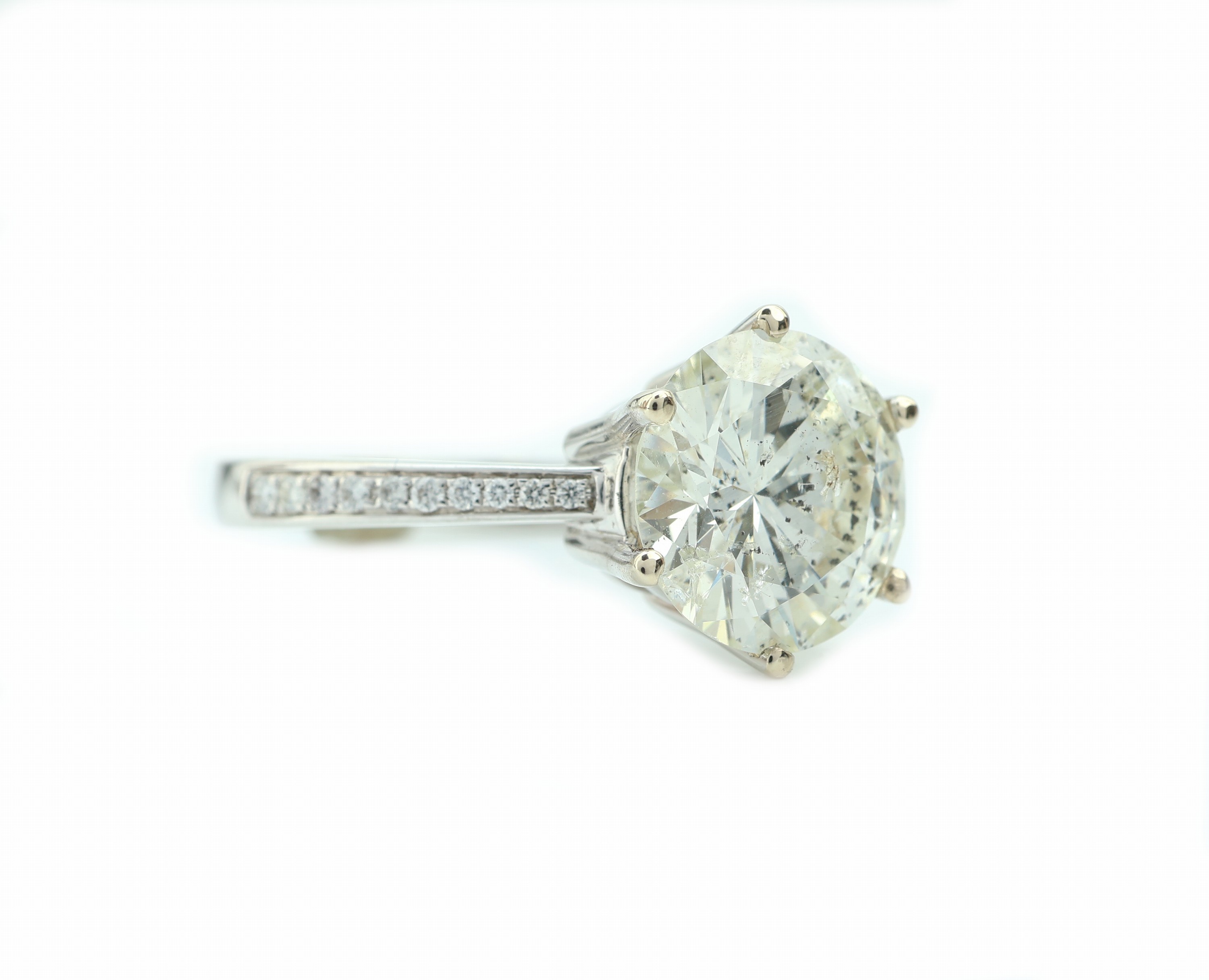 Detail b: 18 kt Gold Brillant-Ring, WG 750/000, Brillant ca. 4.62 ct l.get.Weiß-get.Weiß/p (beh.), seitl. flankiert von Brillanten zus. ca. 0.13 ct ...
