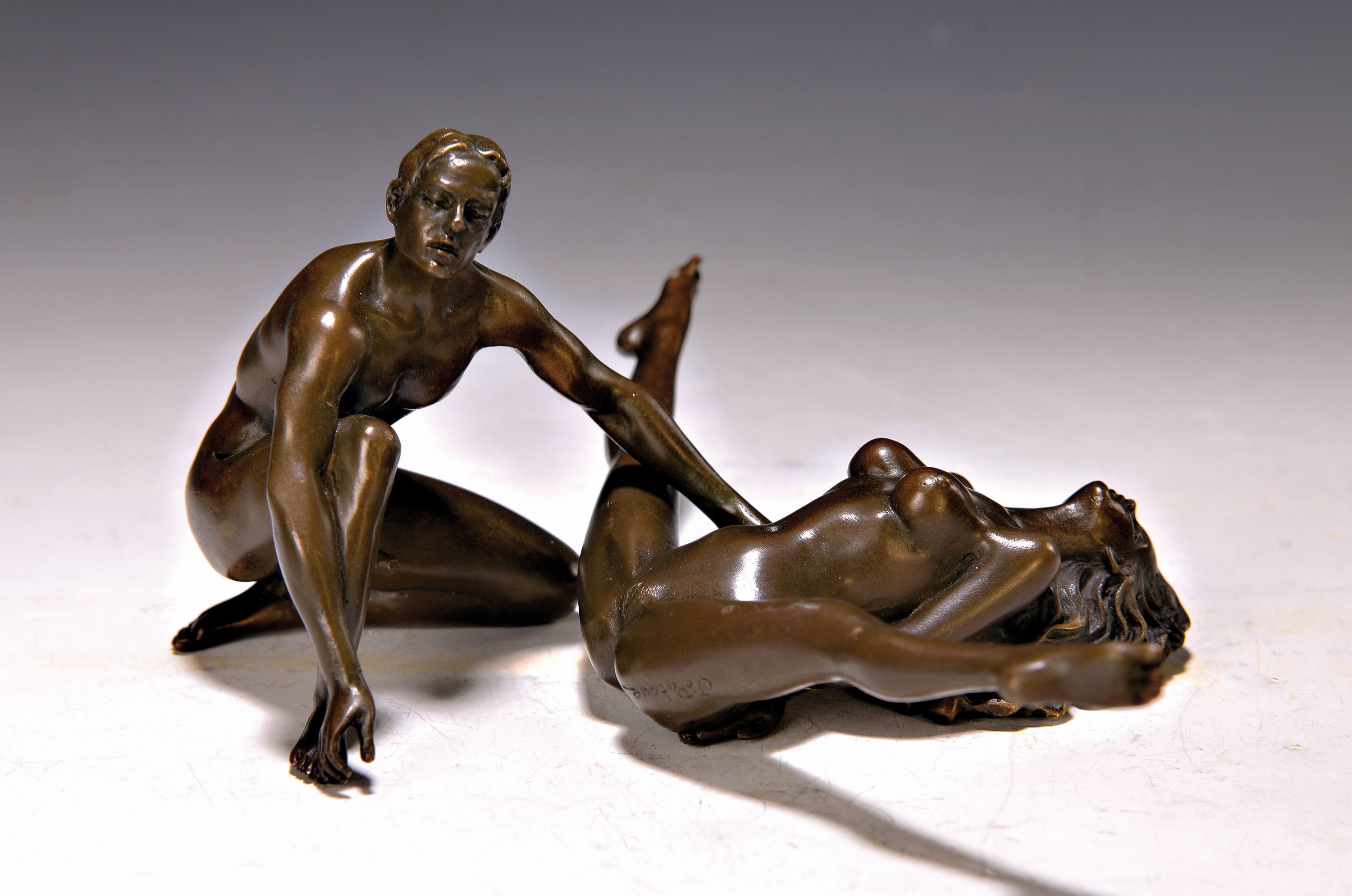 Detail a: Zwei erotische Bronzeskulpturen, a. nach Bruno Zach, liegender Akt, auf Marmorplatte, ca. 6.5 x 18 x 10 cm und b. Jean Patoue, Paris, zweiteilige ...