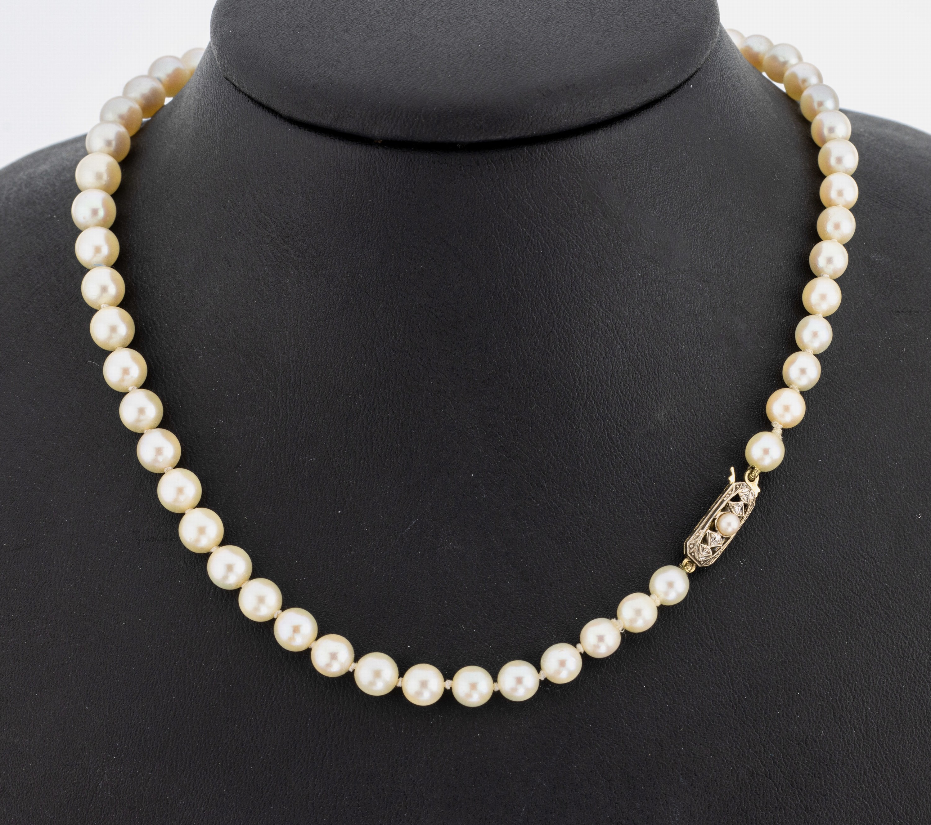 Lange Akoyazuchtperlenkette, an 14 kt Gold Schmuckschließe, cremef. Perlen im Verlauf,D. ca. 5.1 - 8.6 mm, WG Schließe mit Perle undDiamanten, ...