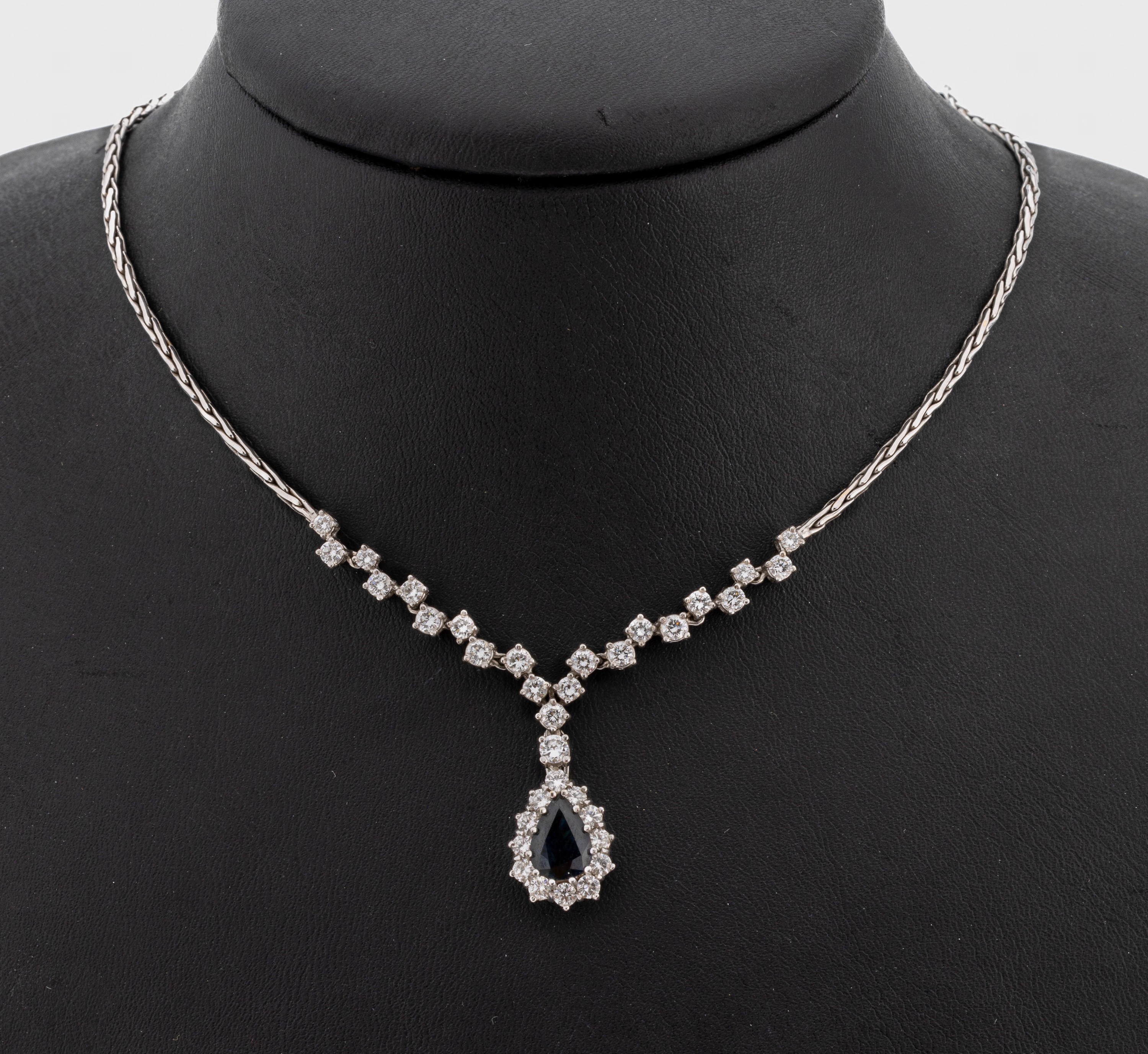 18 kt Gold Brillant-Saphir-Collier, WG 750/000, Mittelteil bes. mit 34 Brillanten zus. ca. 2.00 ct feines Weiß-Weiß/vvs-si, facett. Saphirtropfen ...