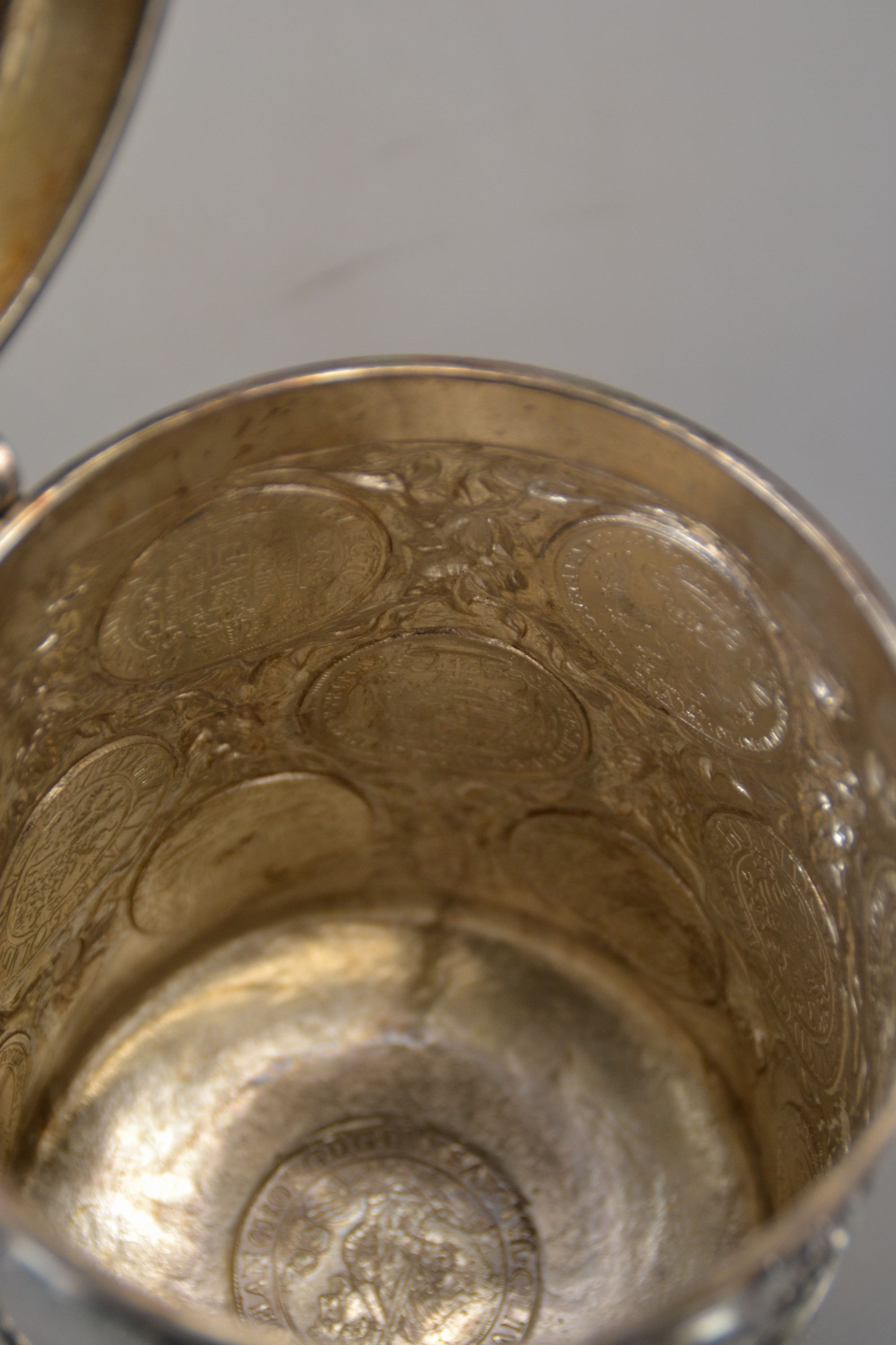 Detail j: Münzkrug, deutsch, wohl Hanau, Mitte 19.Jh., Silber, auf drei Kugelfüßen stehend, Münzreliefs in Wandung, Deckel und Boden, Griff in Form eines ...