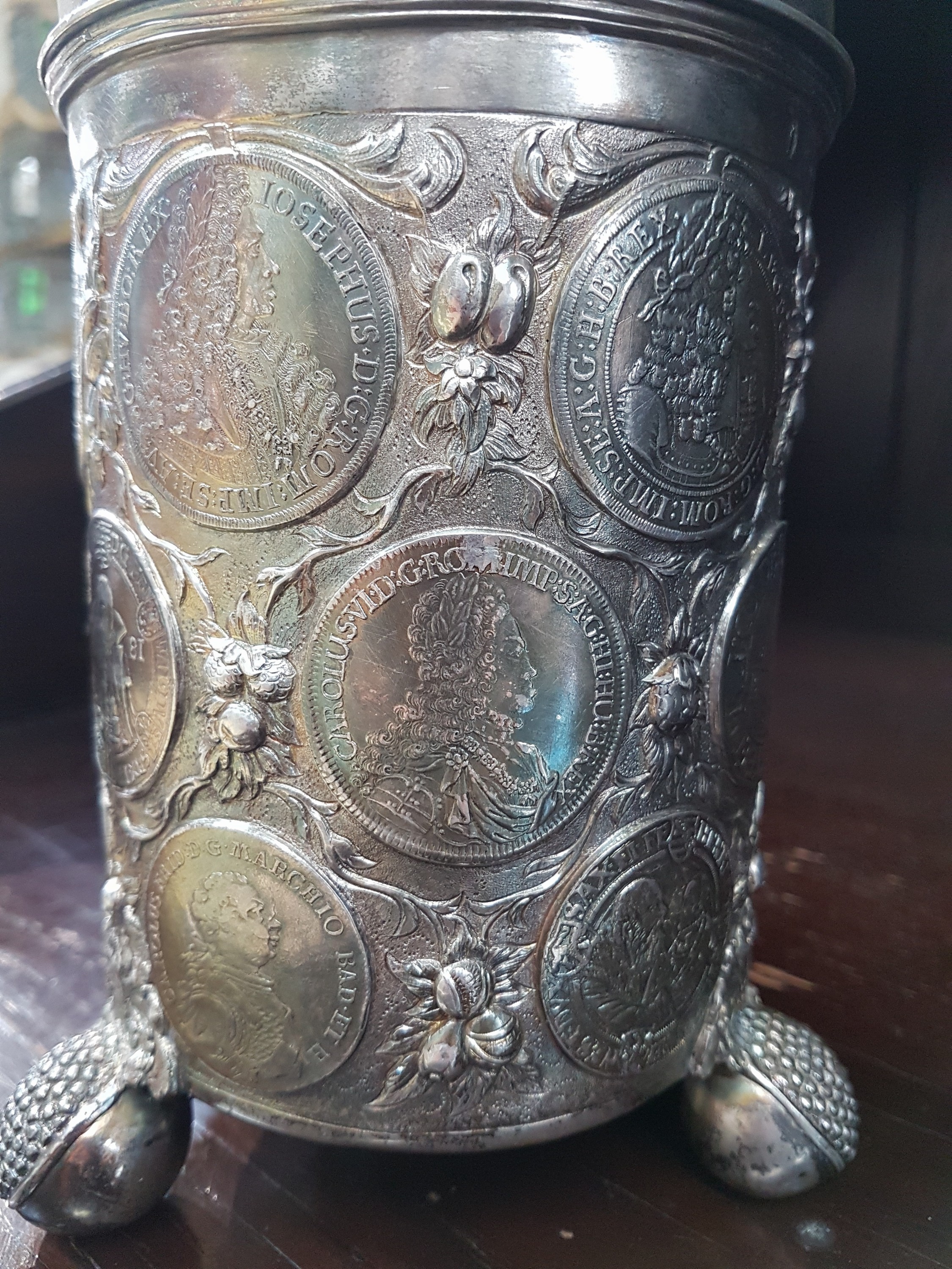 Detail s: Münzkrug, deutsch, wohl Hanau, Mitte 19.Jh., Silber, auf drei Kugelfüßen stehend, Münzreliefs in Wandung, Deckel und Boden, Griff in Form eines ...