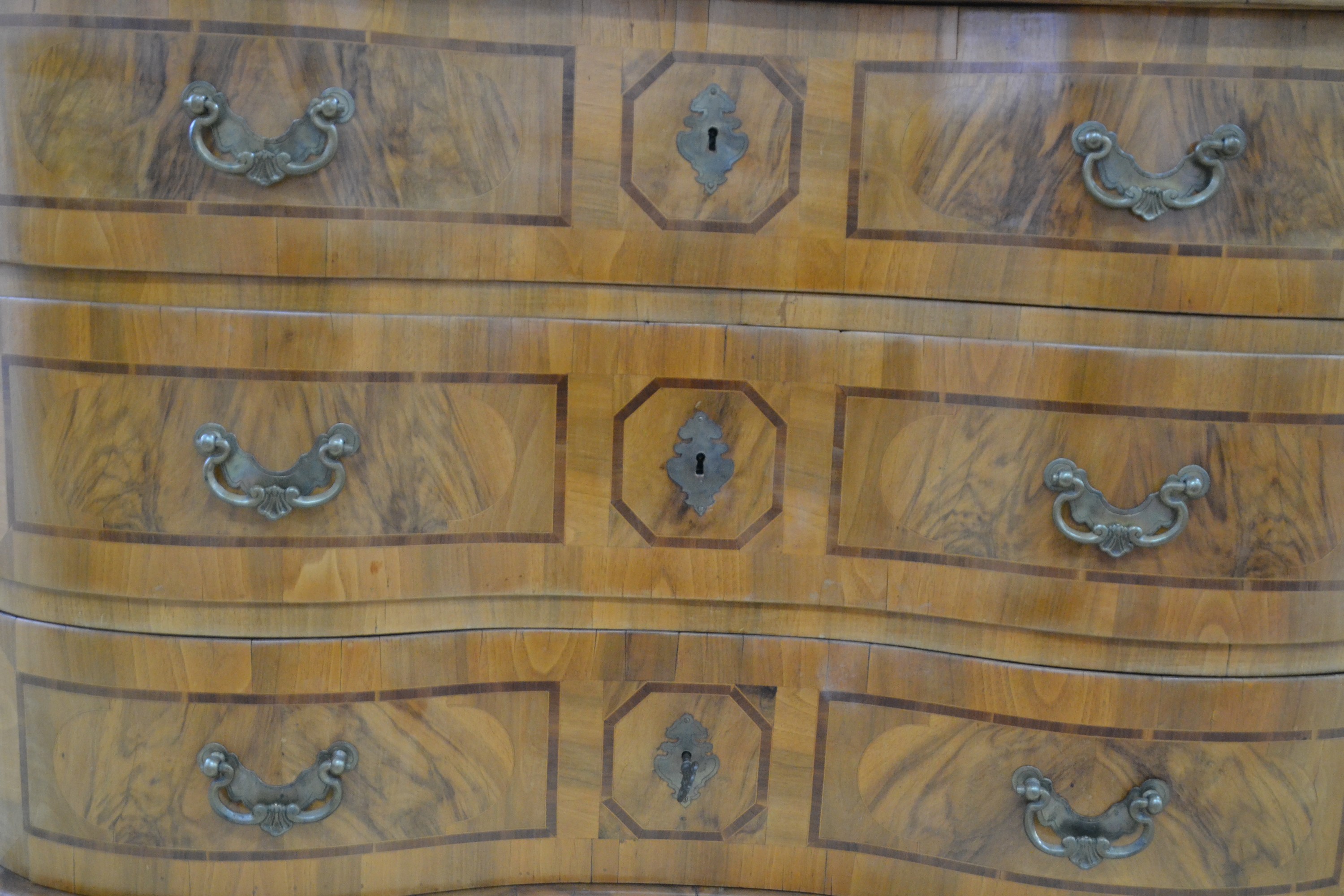 Detail c: Kommode, Barock, Mitte 18. Jh., Nussbaumfurnier, doppelt geschweift, drei Schubladen, Platte mit Blumenintarsien, Schubladen mit Bandeinlagen ...