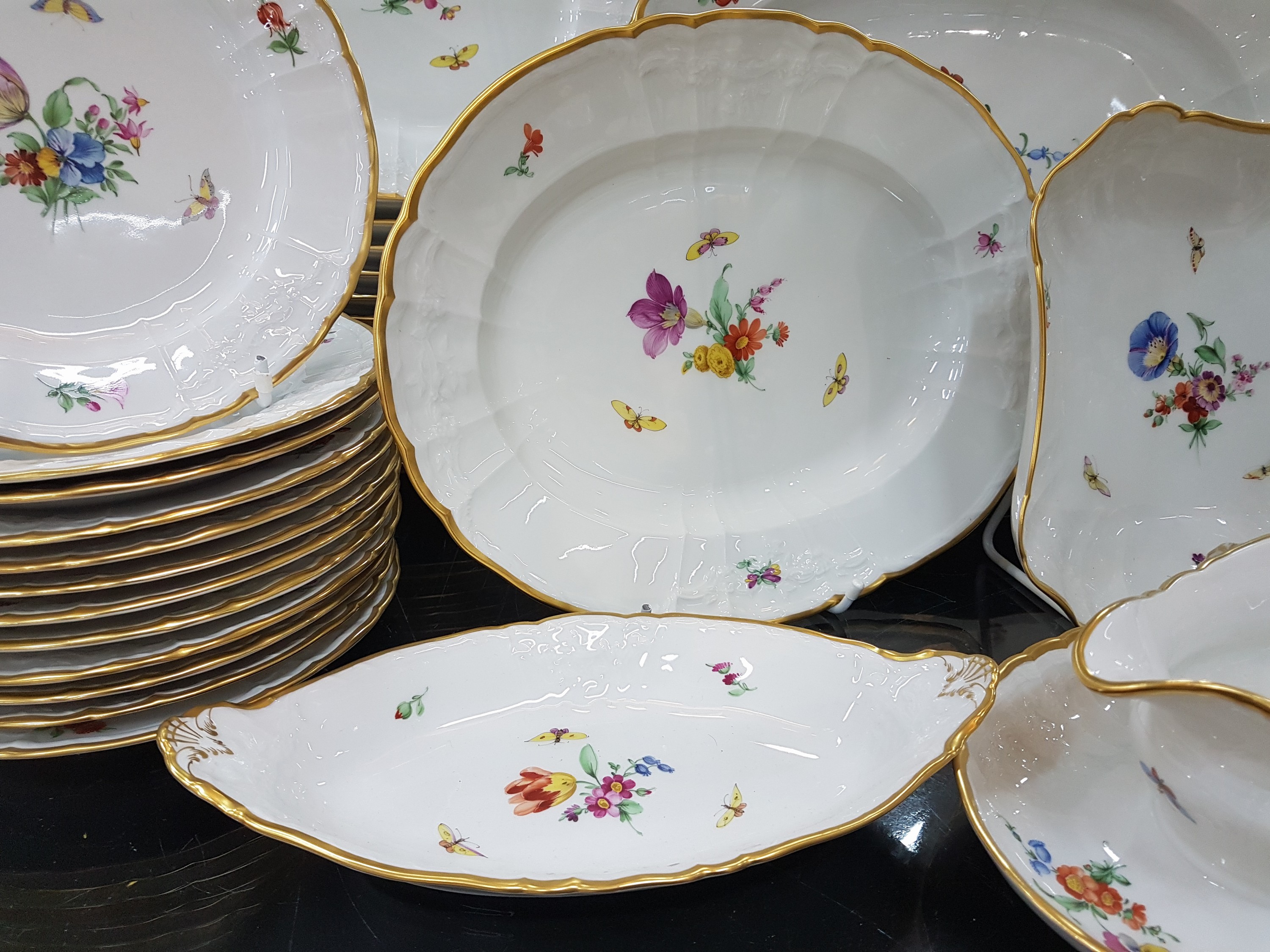 Detail b: Speiseservice, KPM Berlin, 2.Hälfte 20.Jh., Form Rocaille, Porzellan, Goldrand, handbemalt mit Blumen und Schmetterlingen, reliefierte Fahne mit ...