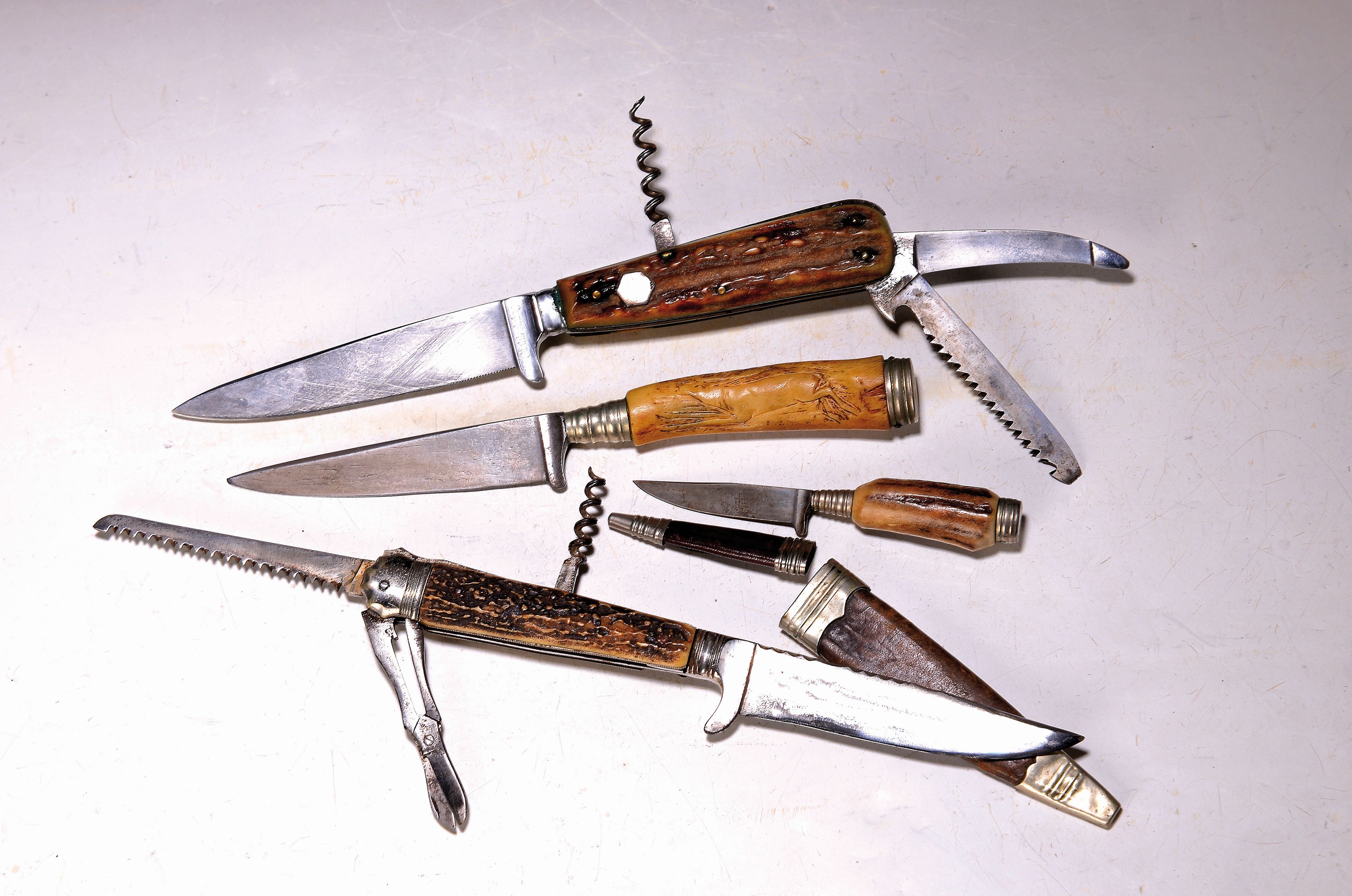 Konvolut aus vier alten Jagdmessern: Ein Jagdnicker von "Franz Chesi Theresienstrasse 57 München". Griffschalen Horn, mit Schere, Säge ...