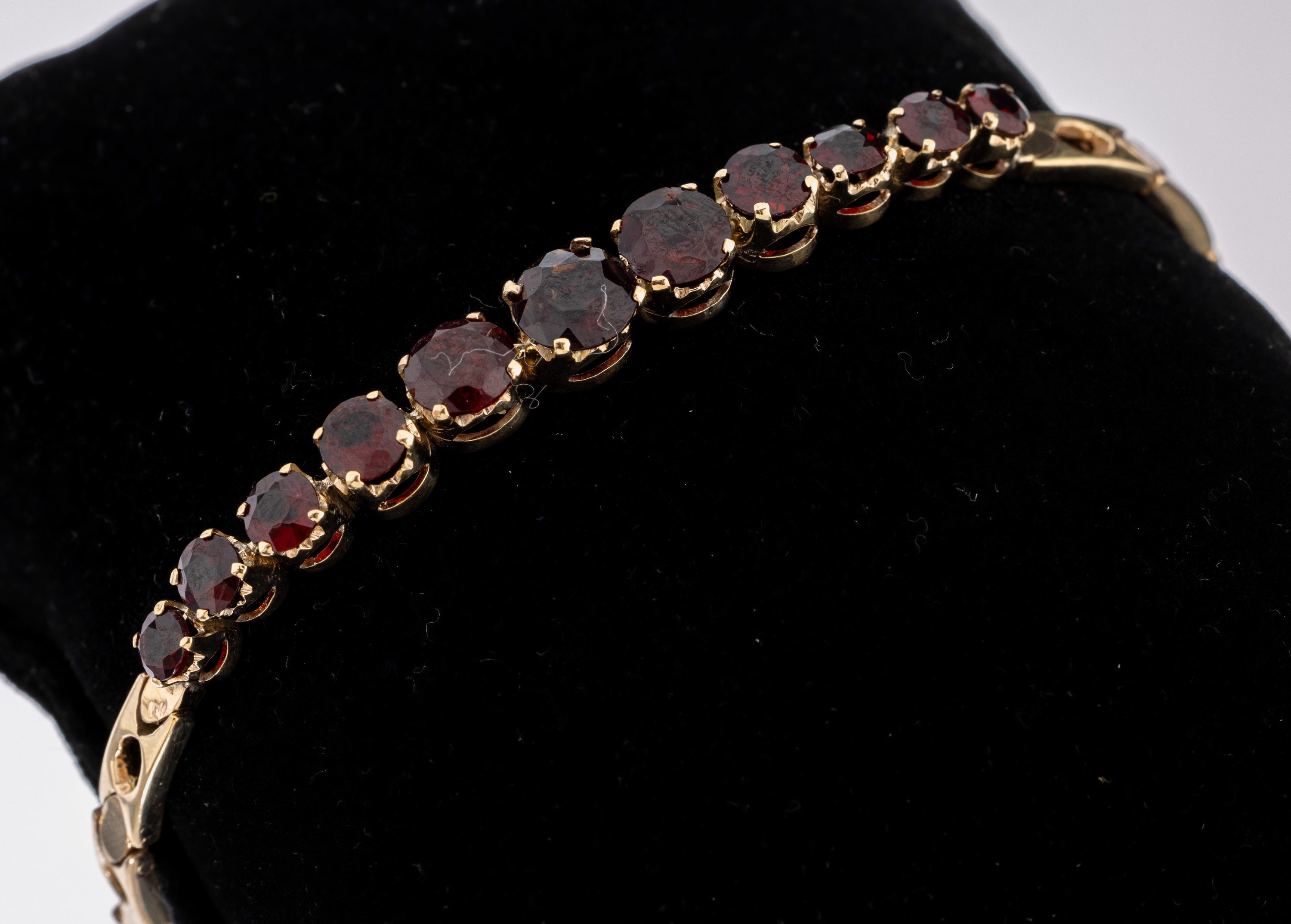 8 kt Gold Granat-Armband, GG 333/000, schlichte Gestaltung, Mittelteil mit 11 rundfacett. Granaten in versch. Größen, L. ca.19 cm, Kastenschloss ...