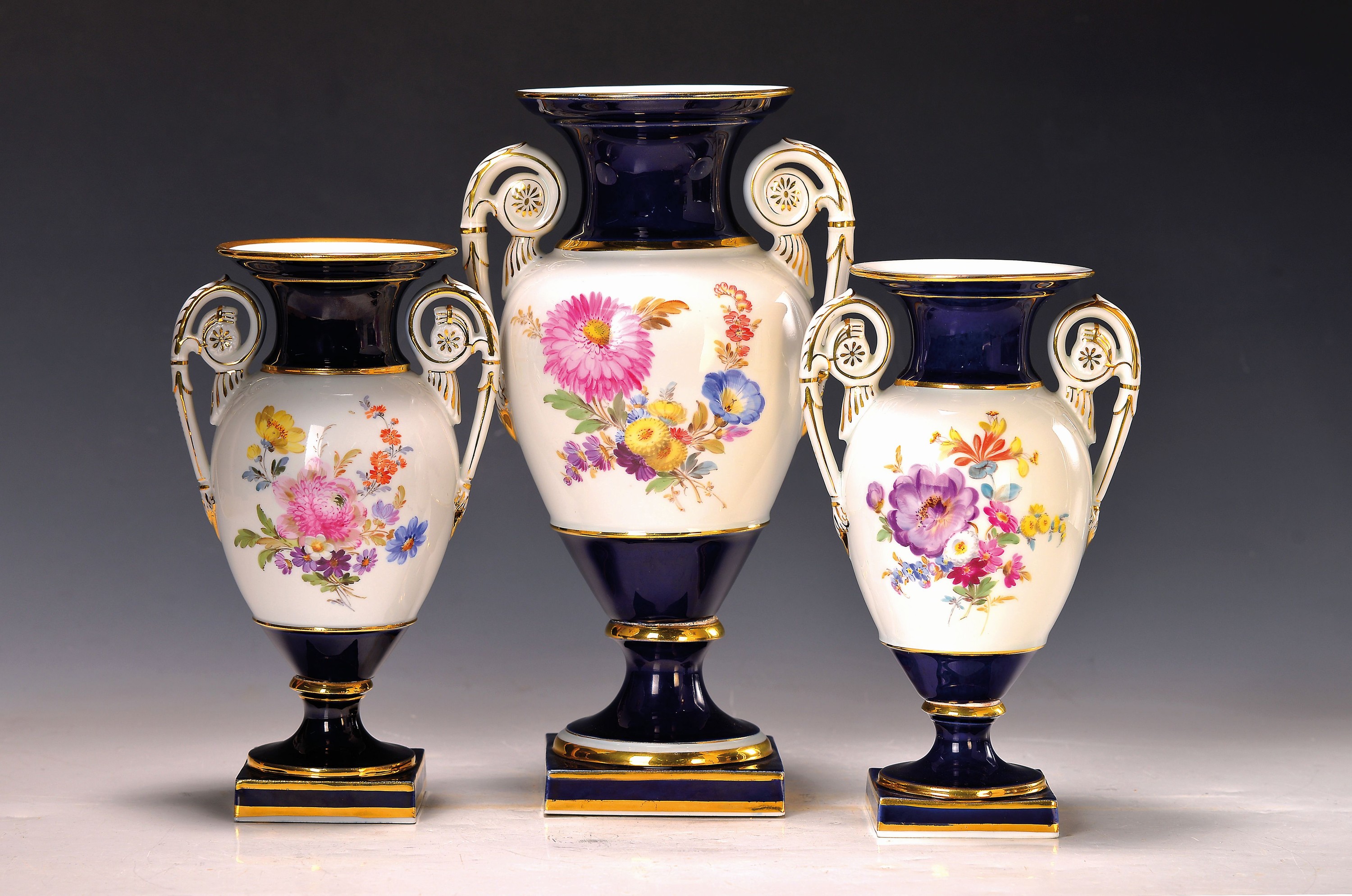 3 Amphorenvasen, Meissen, 1860-1924, Porzellan, königsblauer Fond, Blumenbuketts, Goldstaffage, H. 22/29 cm