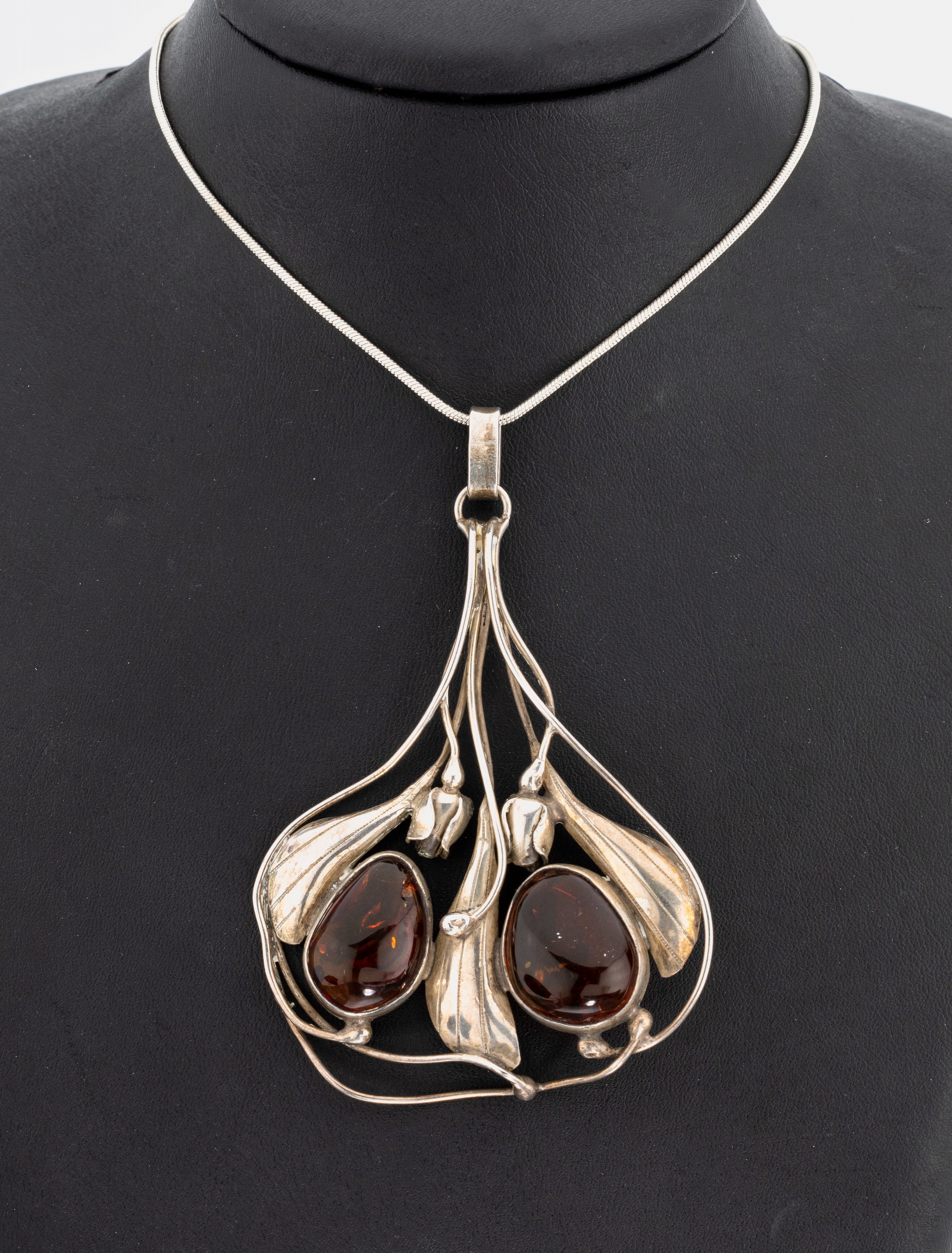 Bernstein-Anhänger, 925er Silber, abstrakt floral mit 2 gr. Bernstein-Cabochons, ca. 9 x 6 cm, an Schlangenkette, L. ca. 75 cm, Karabinerschließe