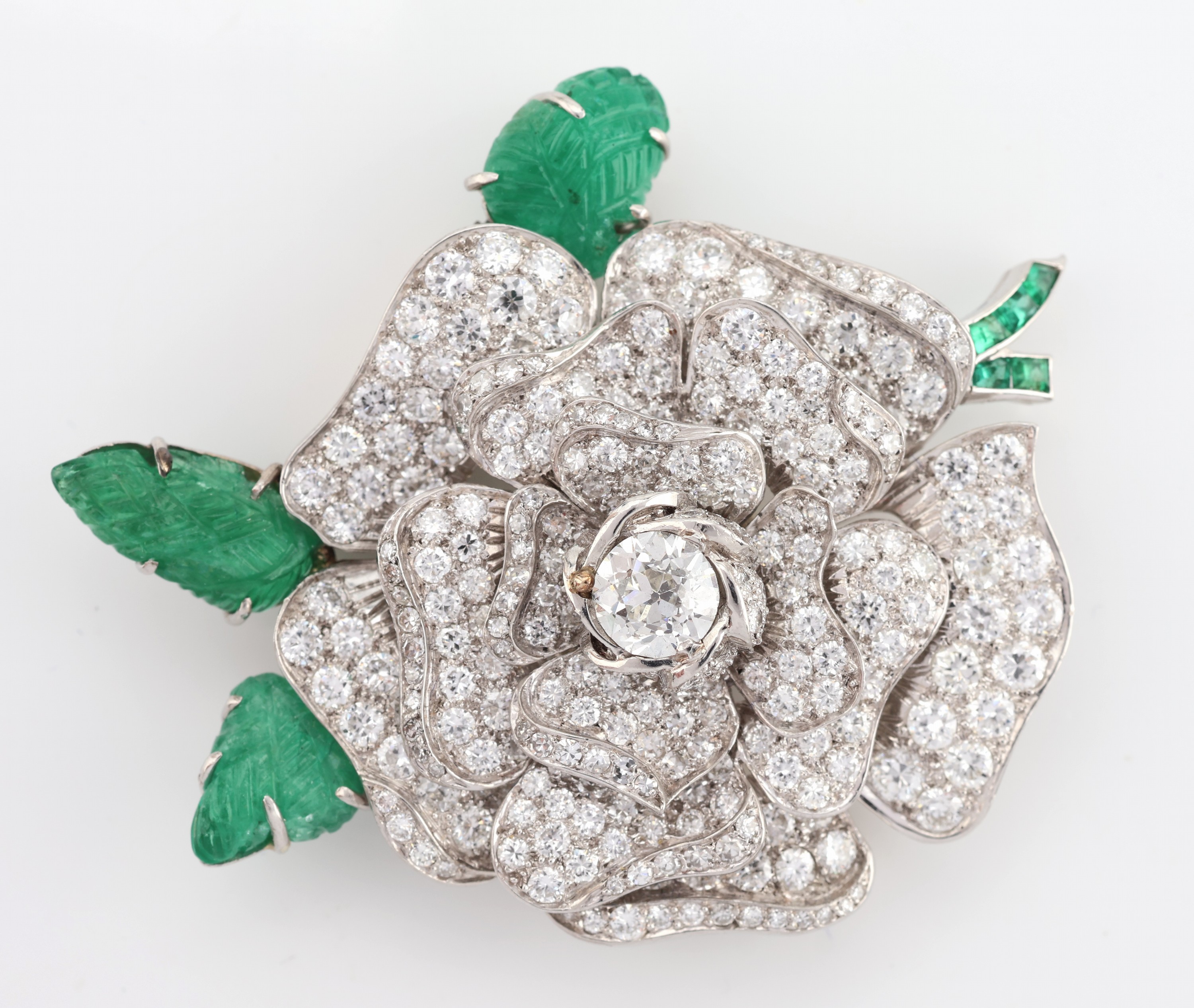 Detail a: 18 kt Gold Diamant-Smaragd-Brosche, WG 750/000 gepr., plastische Darstellung einer Rosenblüte, mittig Altschliffdiamant ca. 1.10 ct l.get.Weiß/p1, ...