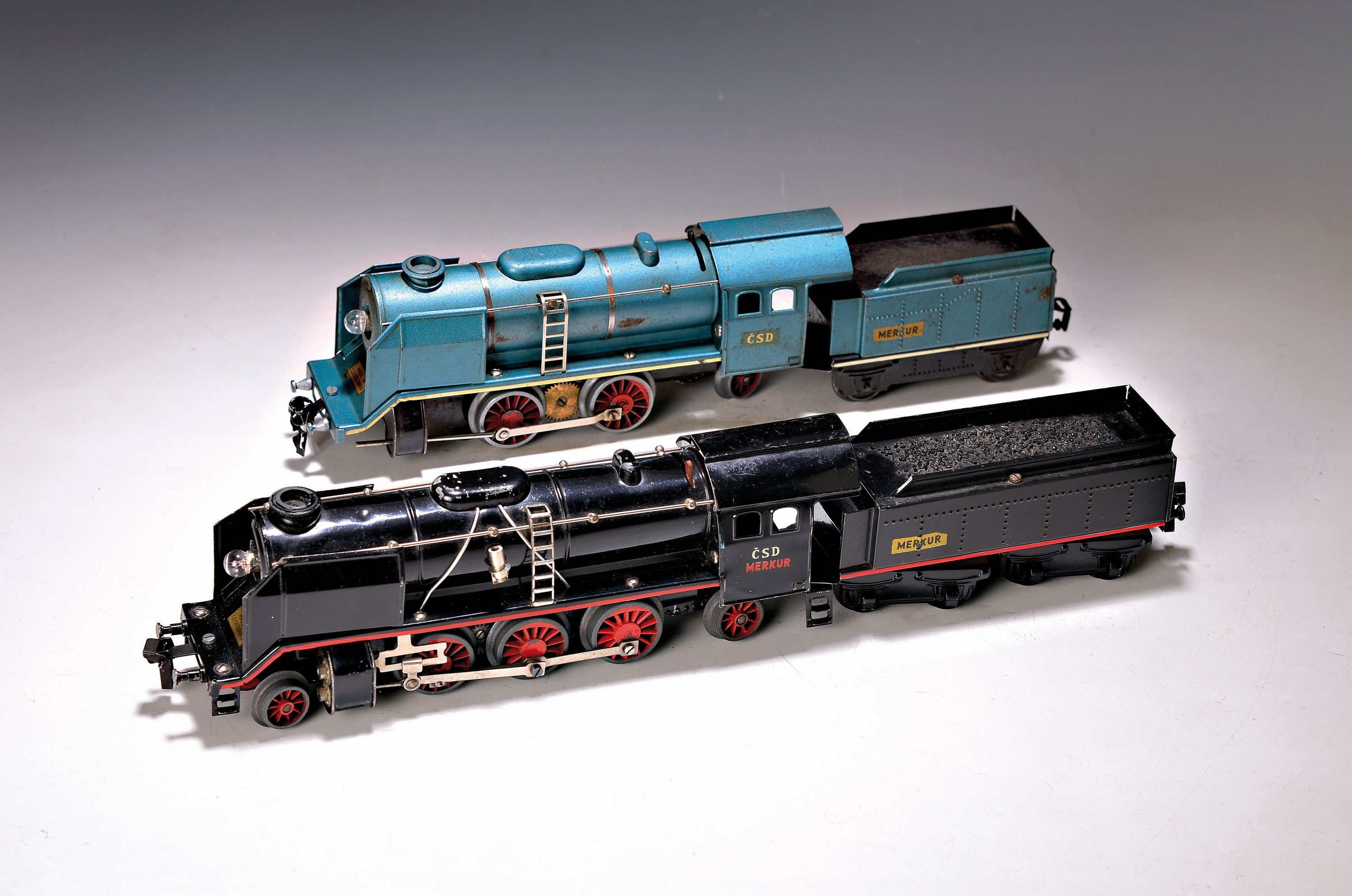 2 Modelleisenbahnen Spur 0, Merkur, 1947-1968 , 2 Schlepptenderloks blau/schwarz, Lok je mit elektr. Stirnlampe, Handumschaltung, Lok und Tender, ...