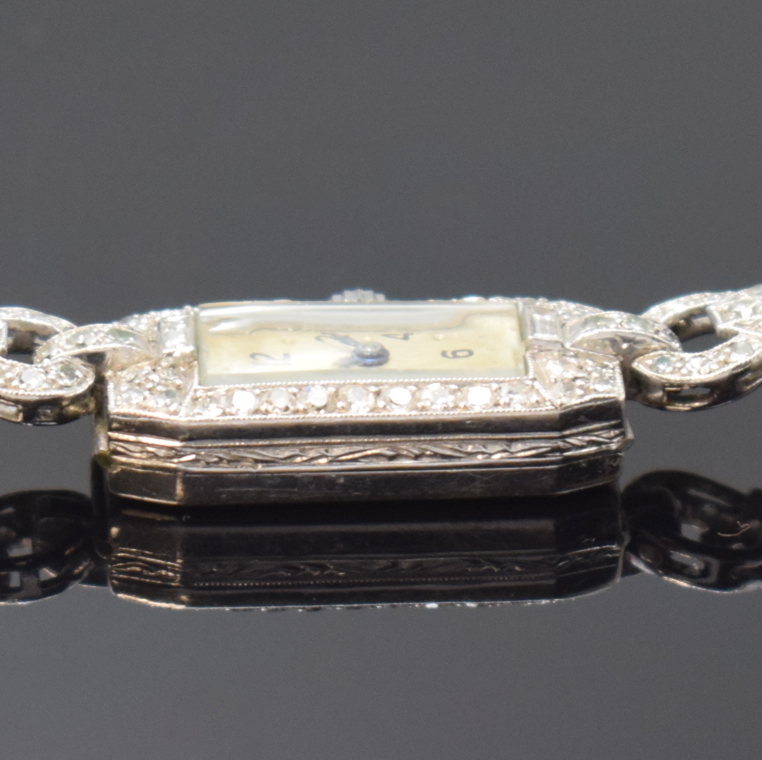 Detail c: Art-Deco Damenarmbanduhr mit Diamanten in Platin, Schweiz um 1920, Handaufzug, Scharniergeh., Lünette sowie Bandanstöße aufw. m. Diamanten bes., ...