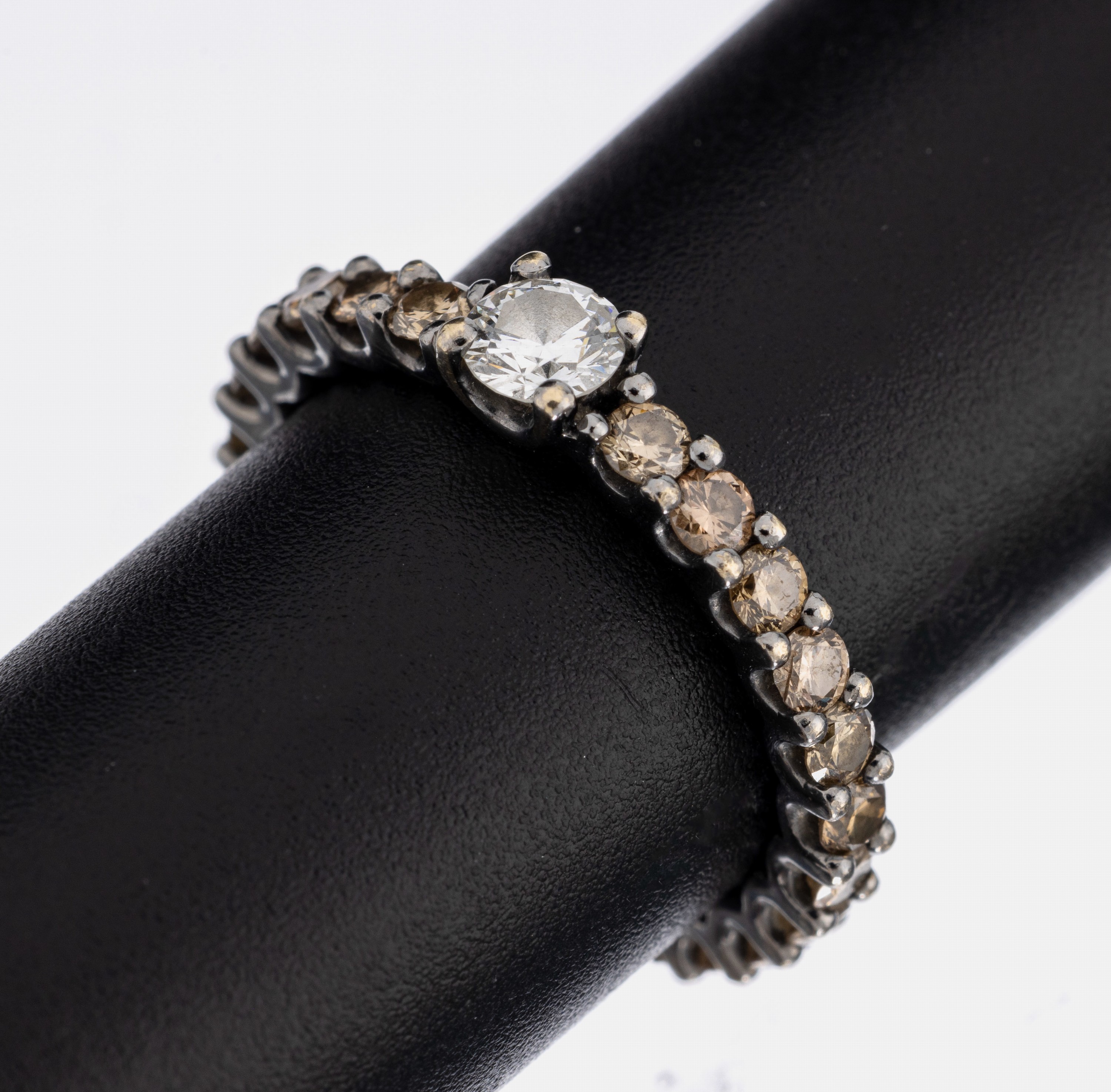 18 kt Gold Brillant-Ring, WG 750/000 geschwärzt, erhaben gefasster Brillant ca. 0.25 ct Weiß/si (min. besch.), 25 Brillanten zus. ca. 1.00 ct ...